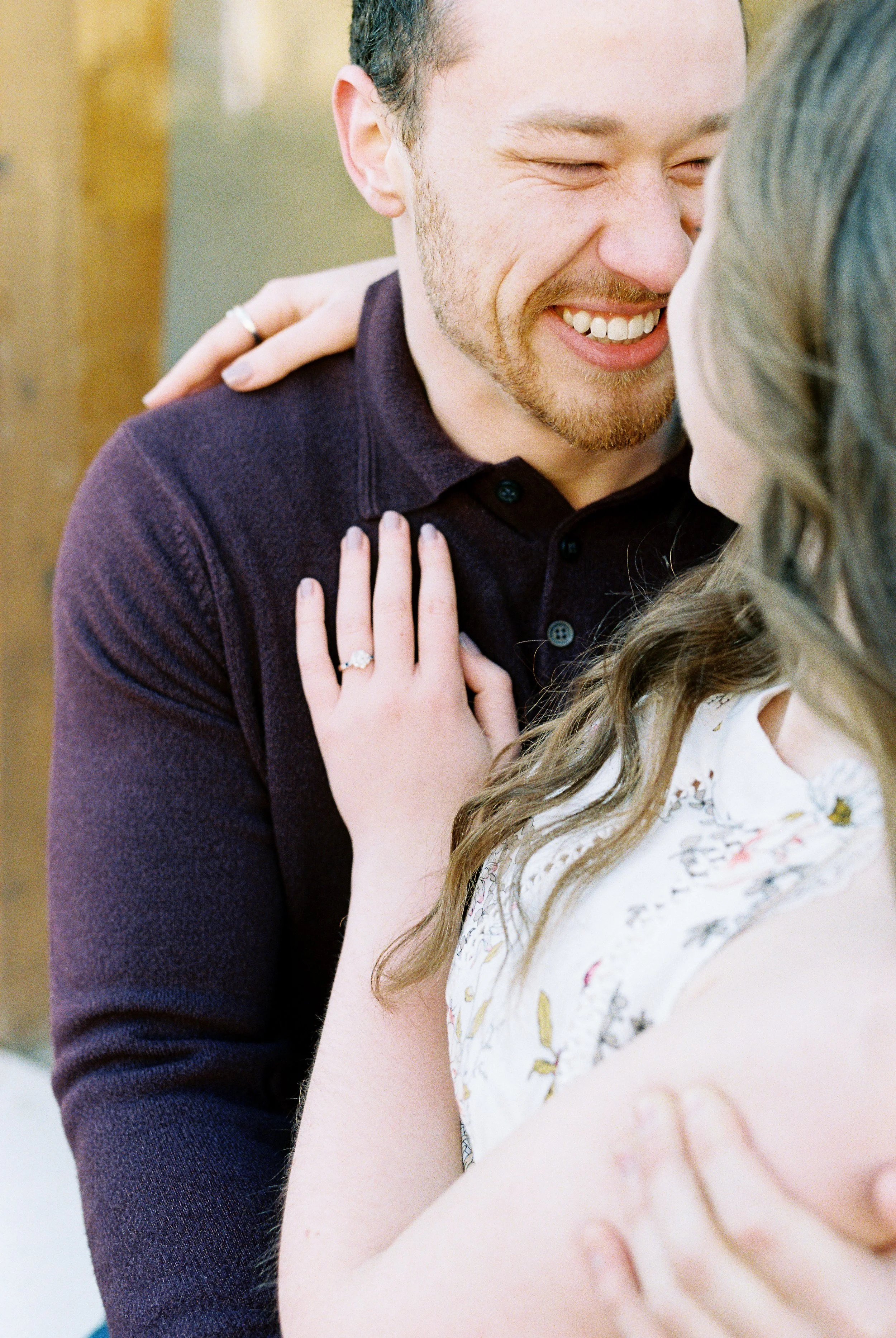 Conner laughs with Maddie's hand on his shoulder during their engagement session in Dallas, Georgia.