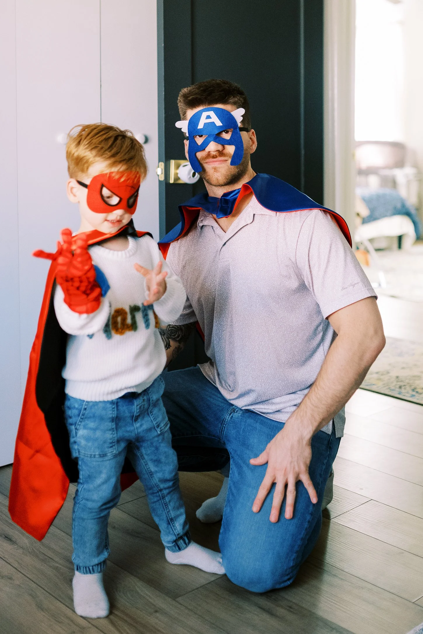 Big brother in a superhero costume peeking playfully through the doorway, Roswell, Georgia