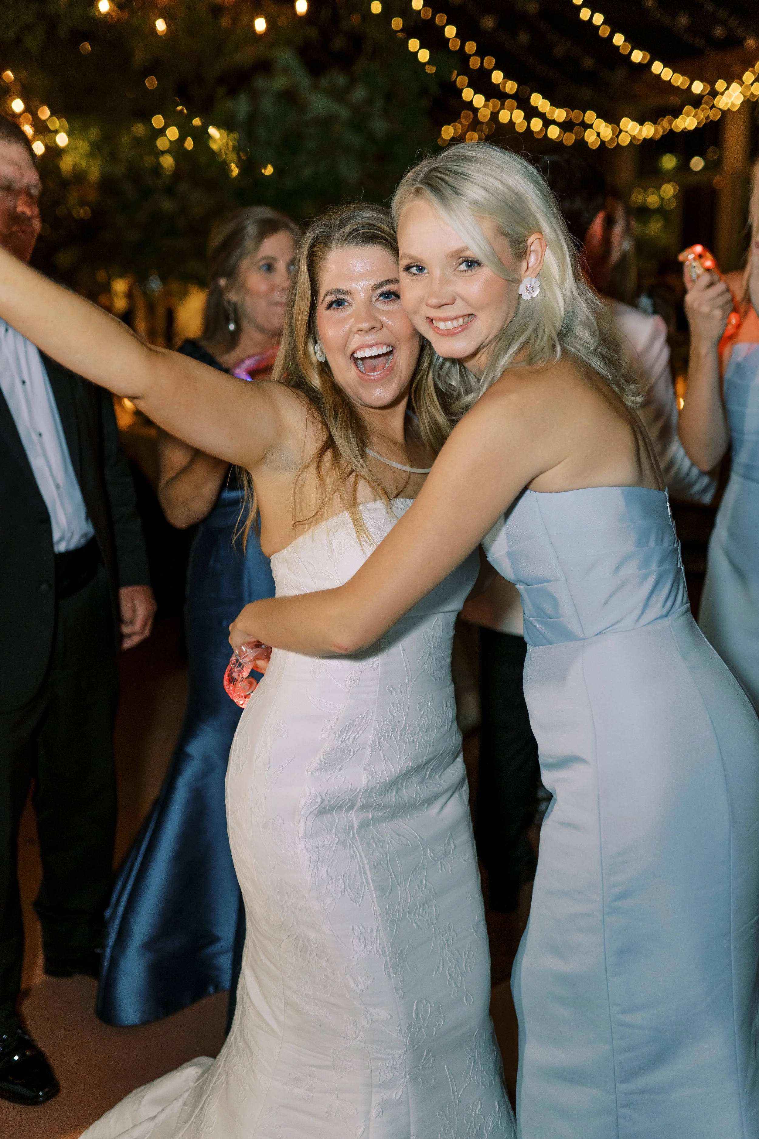 Bride dancing joyfully with bridesmaids at the reception