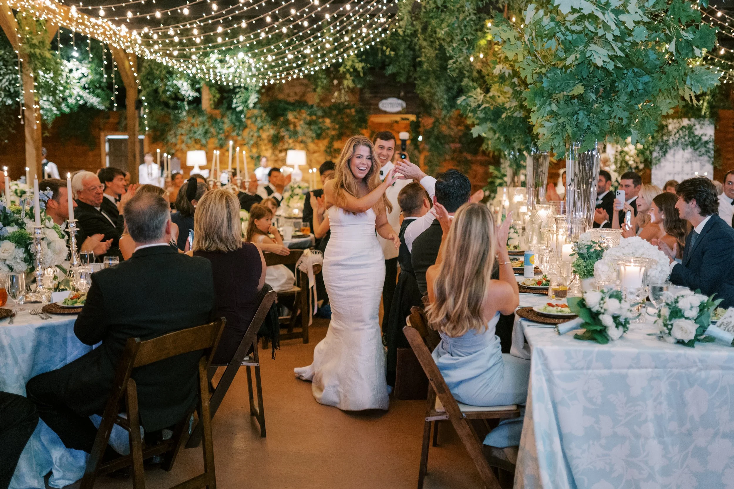 Bride making her grand entrance into the reception as guests applaud