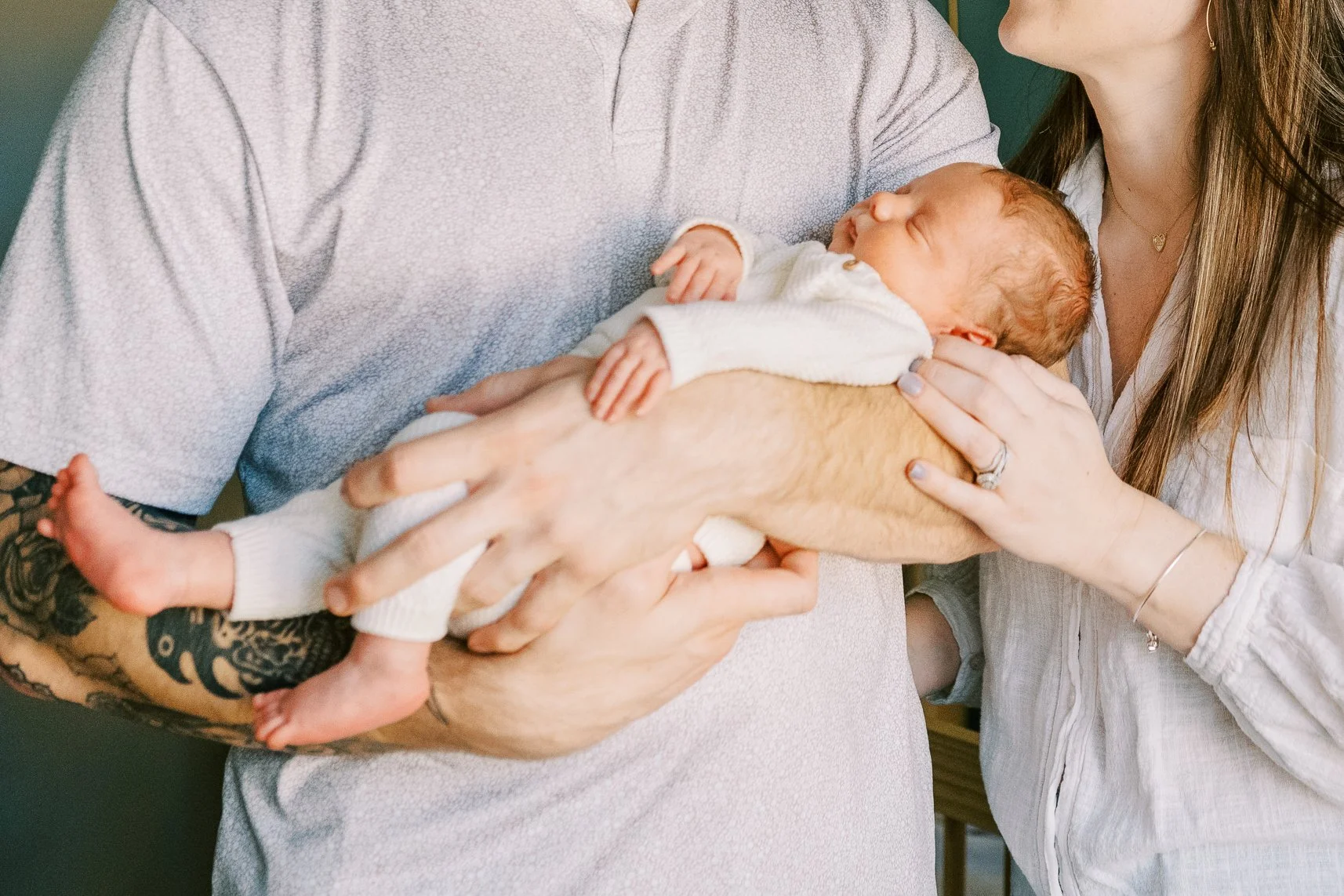 Dad kissing his newborn baby's forehead as he cradles him close, Roswell, Georgia