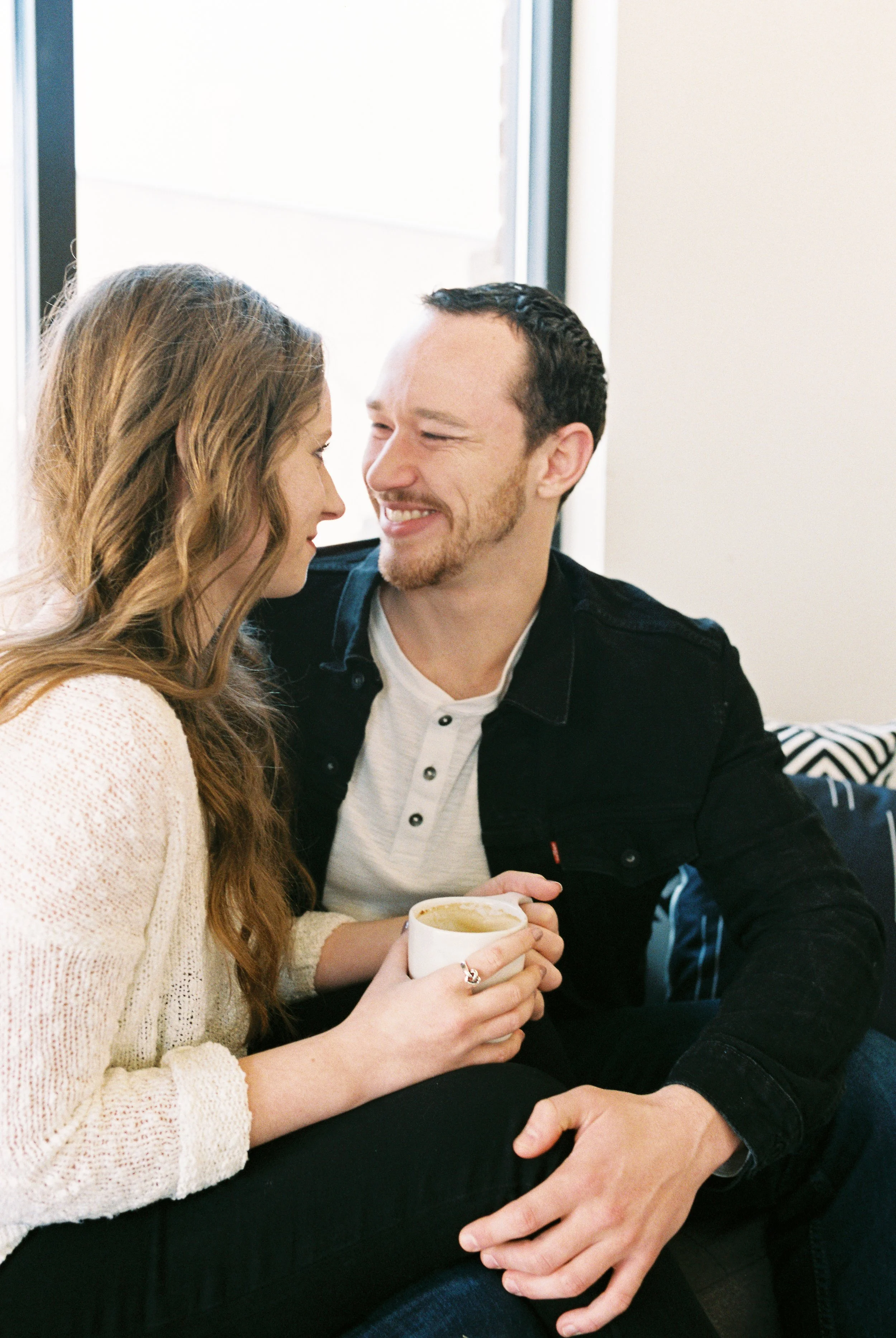 Maddie holds a coffee mug as she and Conner laugh together on a couch in a Dallas, Georgia coffee shop.