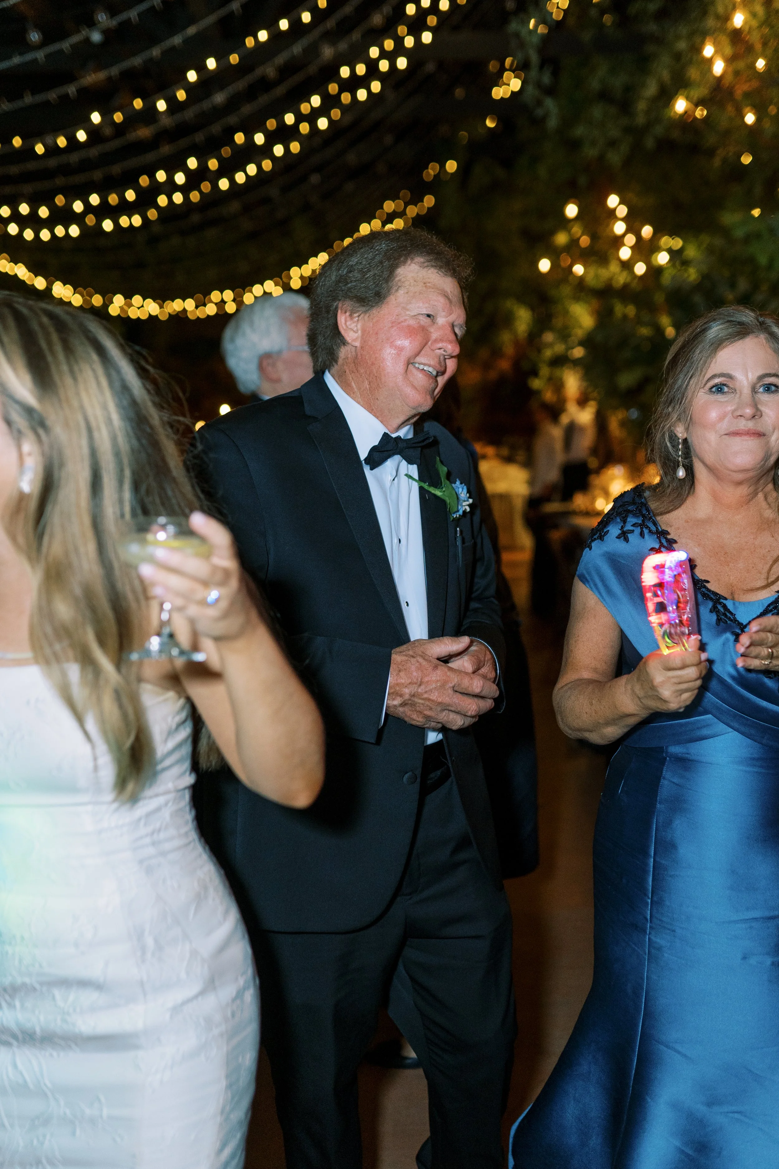 Guests dancing together at the reception under string lights