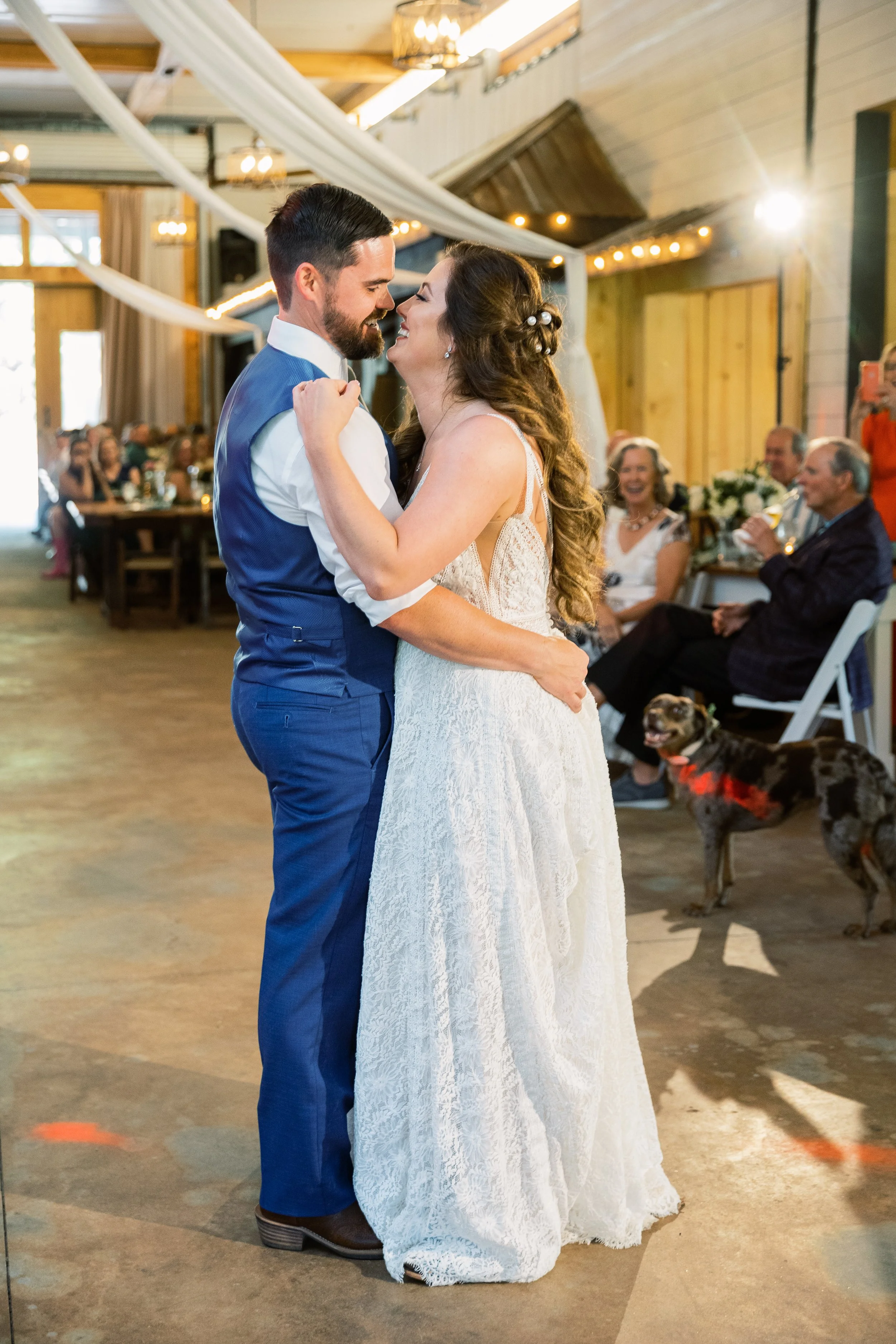 Close-up of the bride and groom dancing together with guests seated in the background