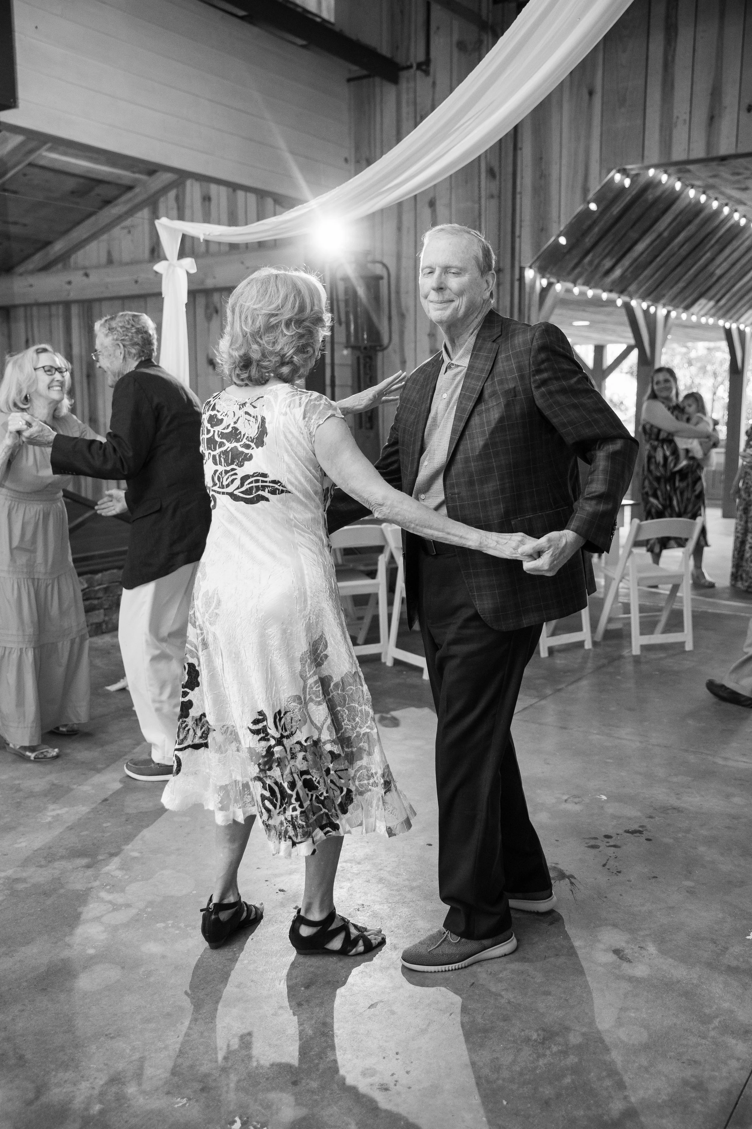 Black and white photo of an older couple dancing together on the dance floor