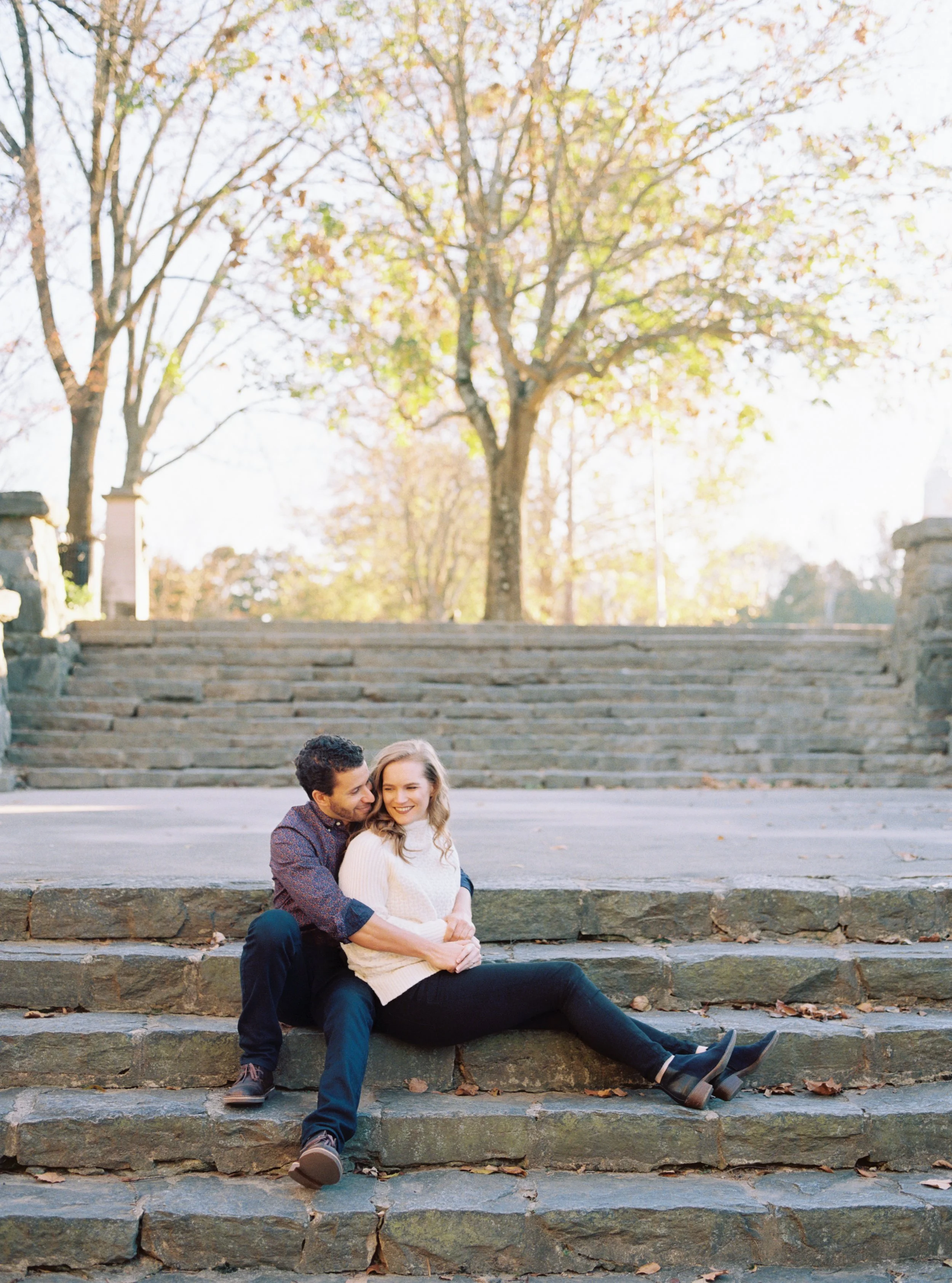 Couple embracing while seated together on stone garden steps