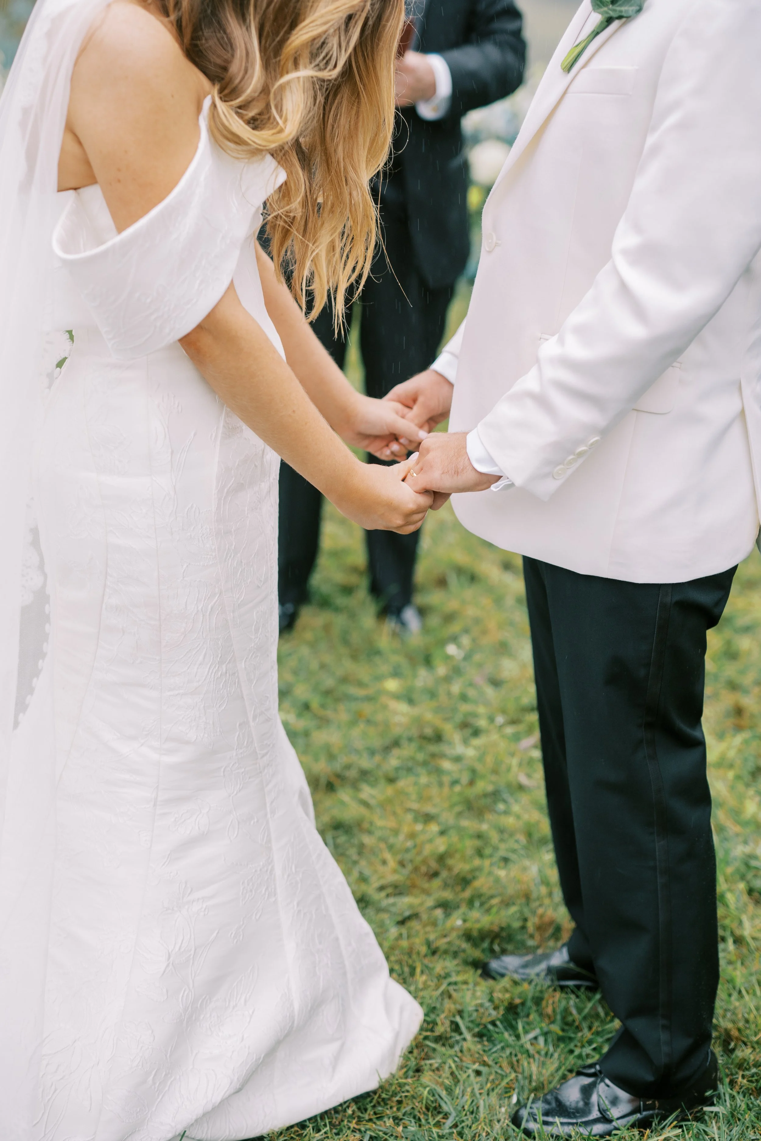 Close-up of the bride and groom holding hands during the ceremony