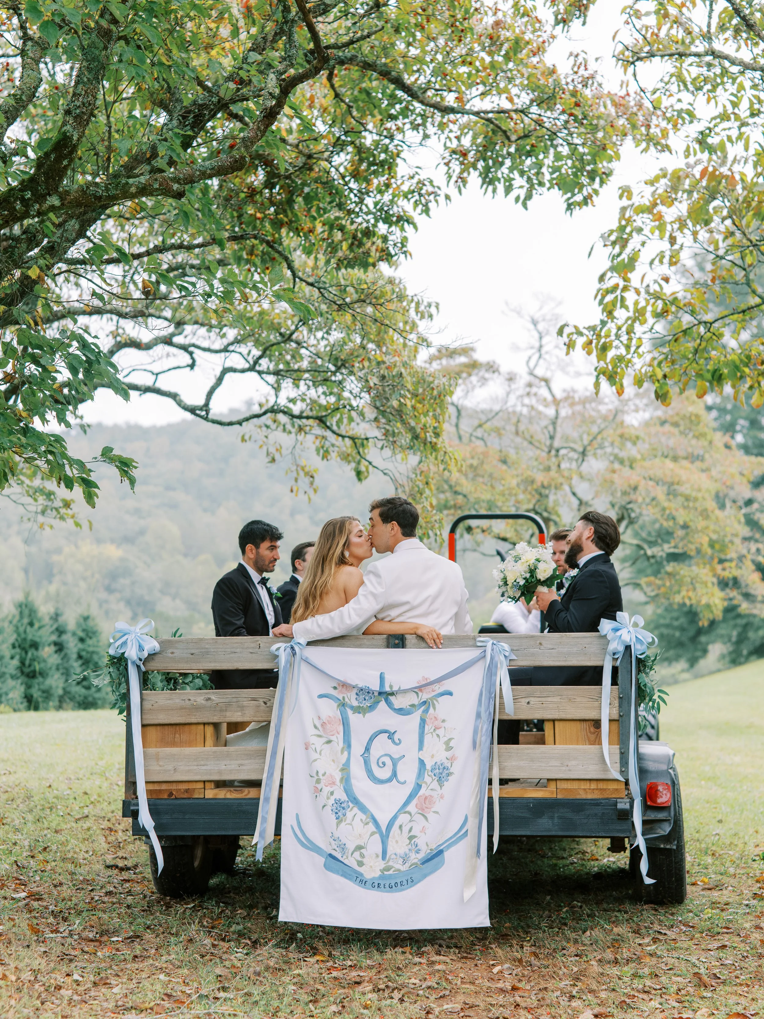 Couple sitting together in the vintage truck bed with monogrammed banner