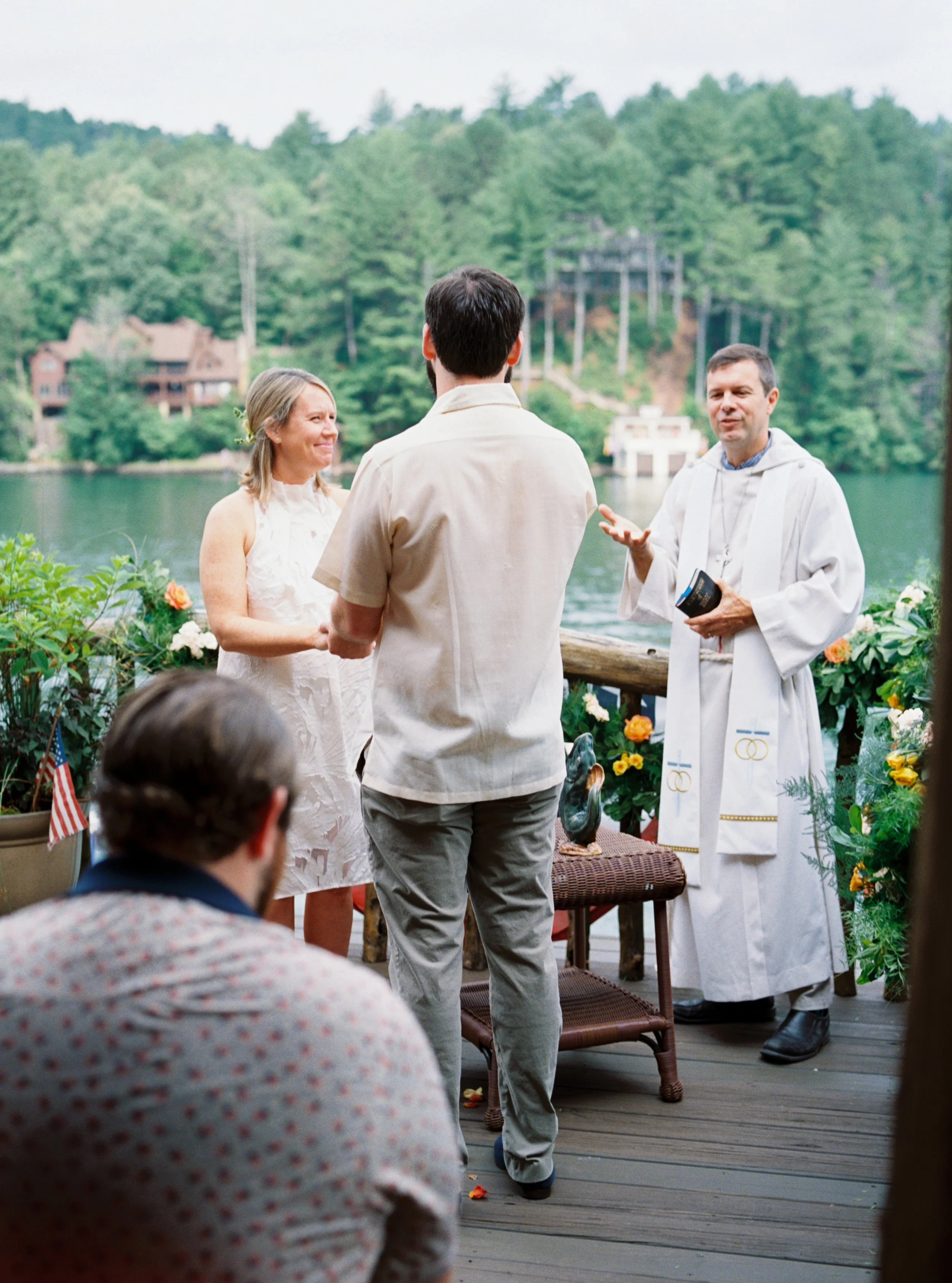 Officiant addressing the bride and groom during the wedding ceremony, surrounded by trees