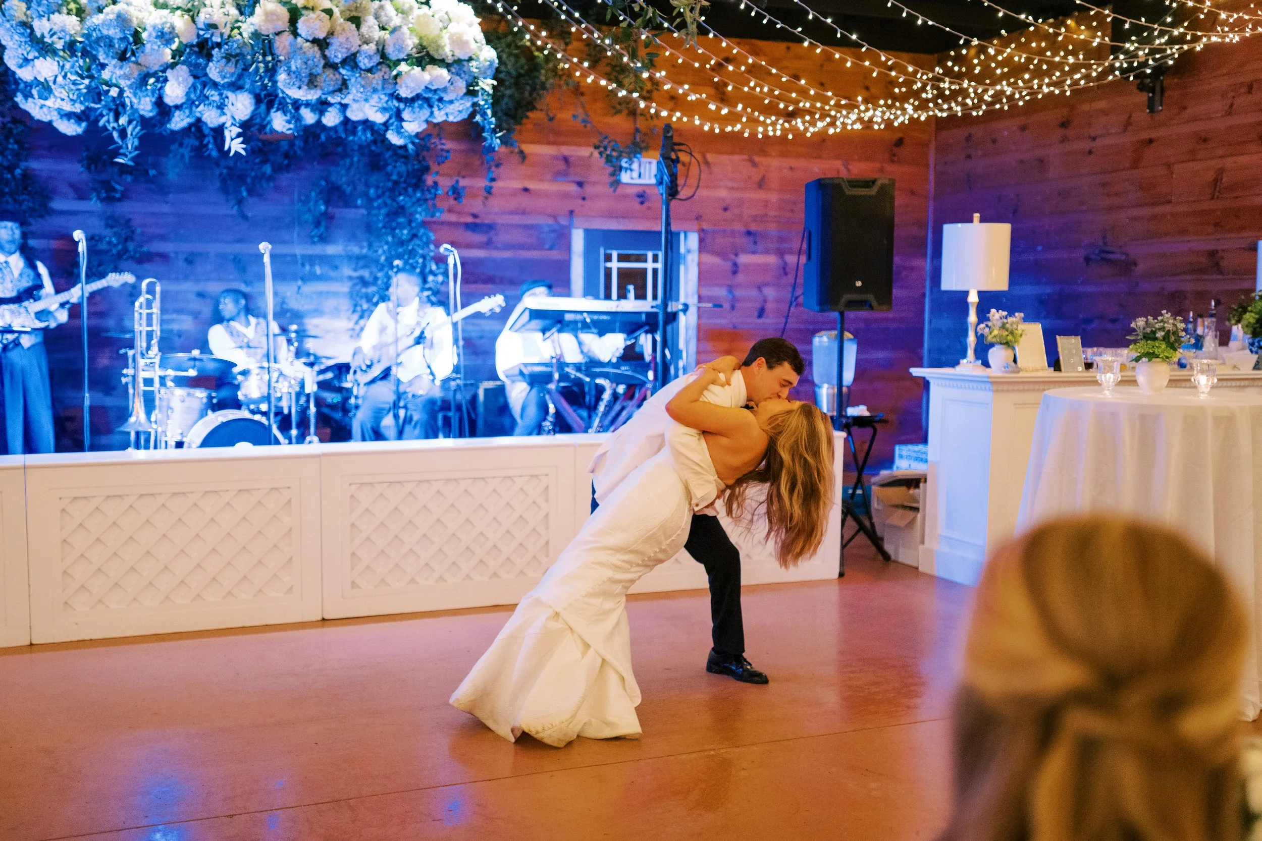 Groom dipping bride during their first dance on the dance floor