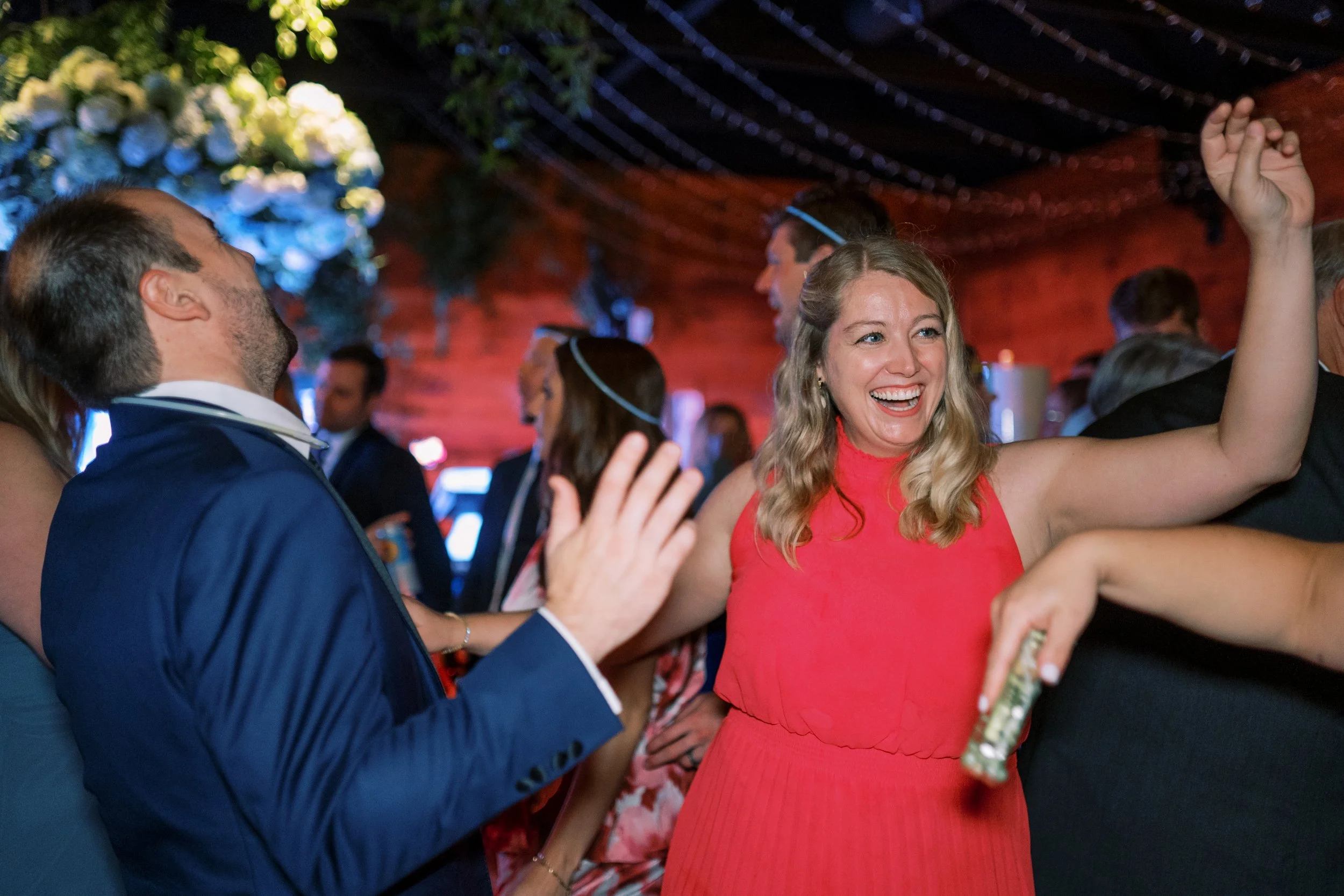 Guests dancing energetically with hands raised at the reception