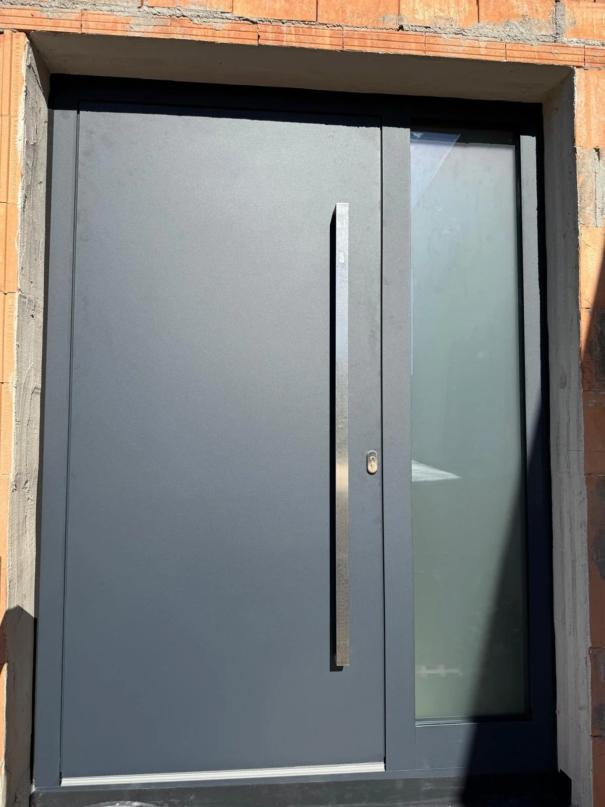 Moderne graue Haustür mit senkrechtem Griff und Seitenglasfenster