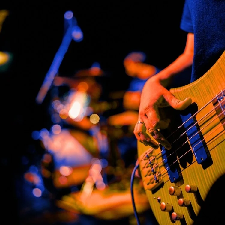Hand strumming a guitar with blurry background