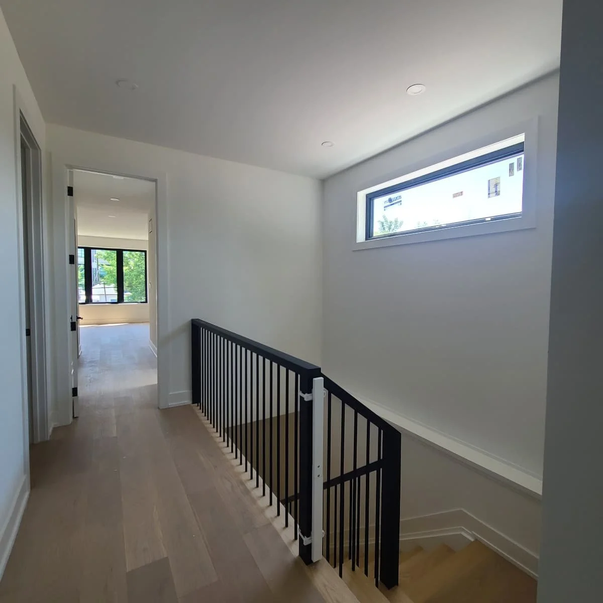 all white with black accent lighted stairwell and hallway.jpg