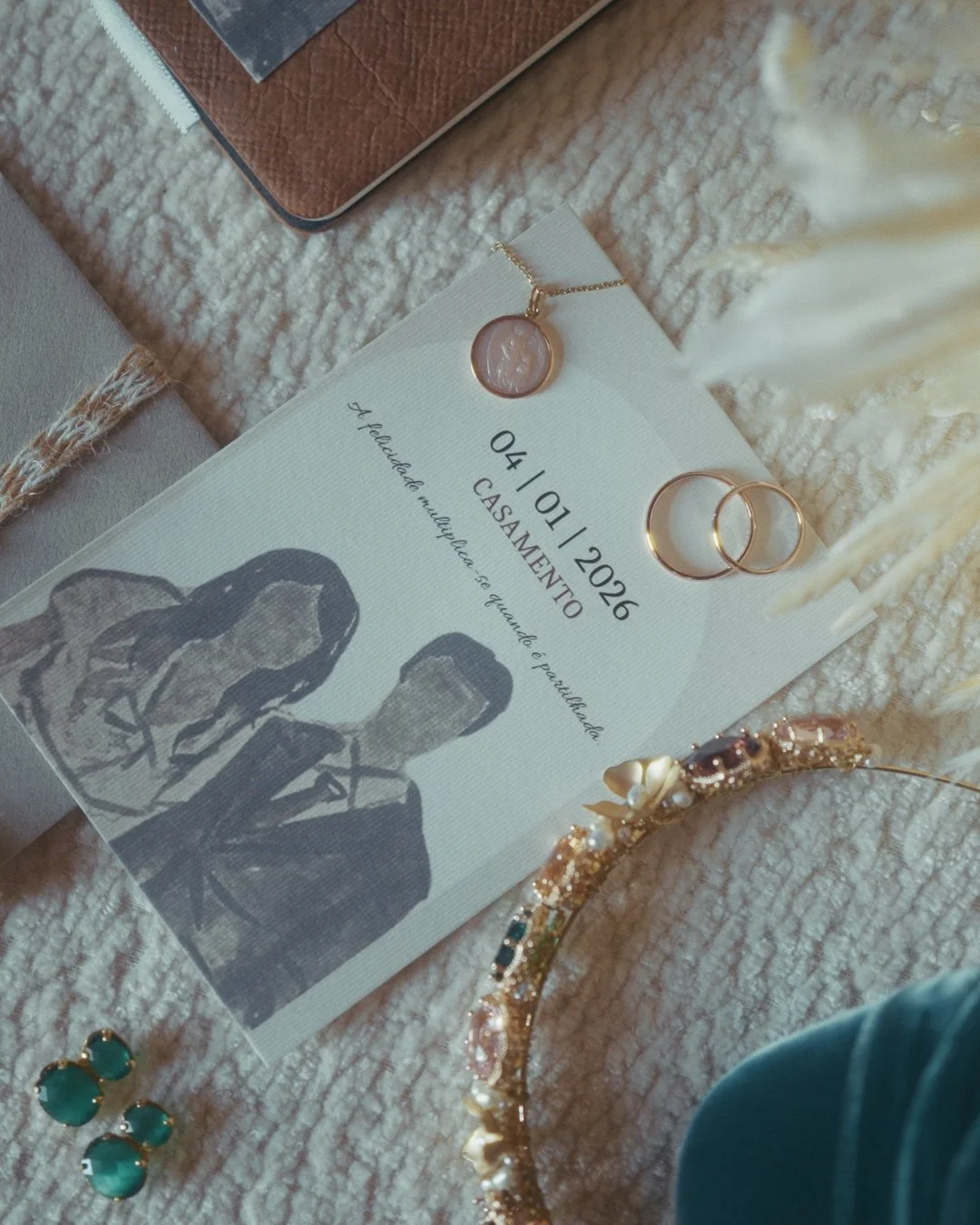 Alianças de casamento e joias sobre um convite personalizado durante os preparativos da noiva.