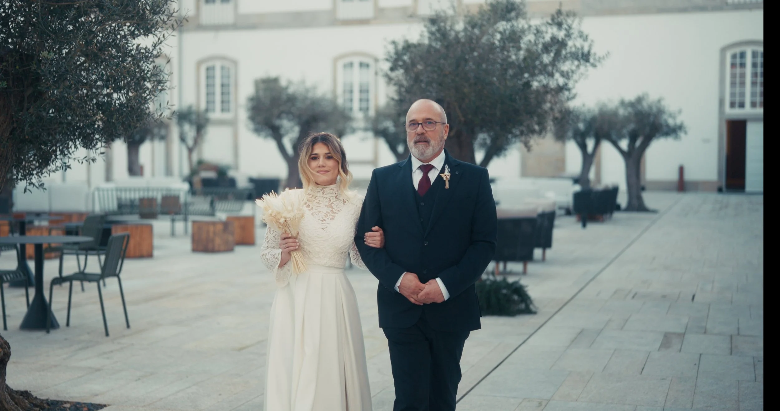 Noiva caminha acompanhada por pai no exterior do antigo Mosteiro de Santa Clara, em Vila do Conde.
