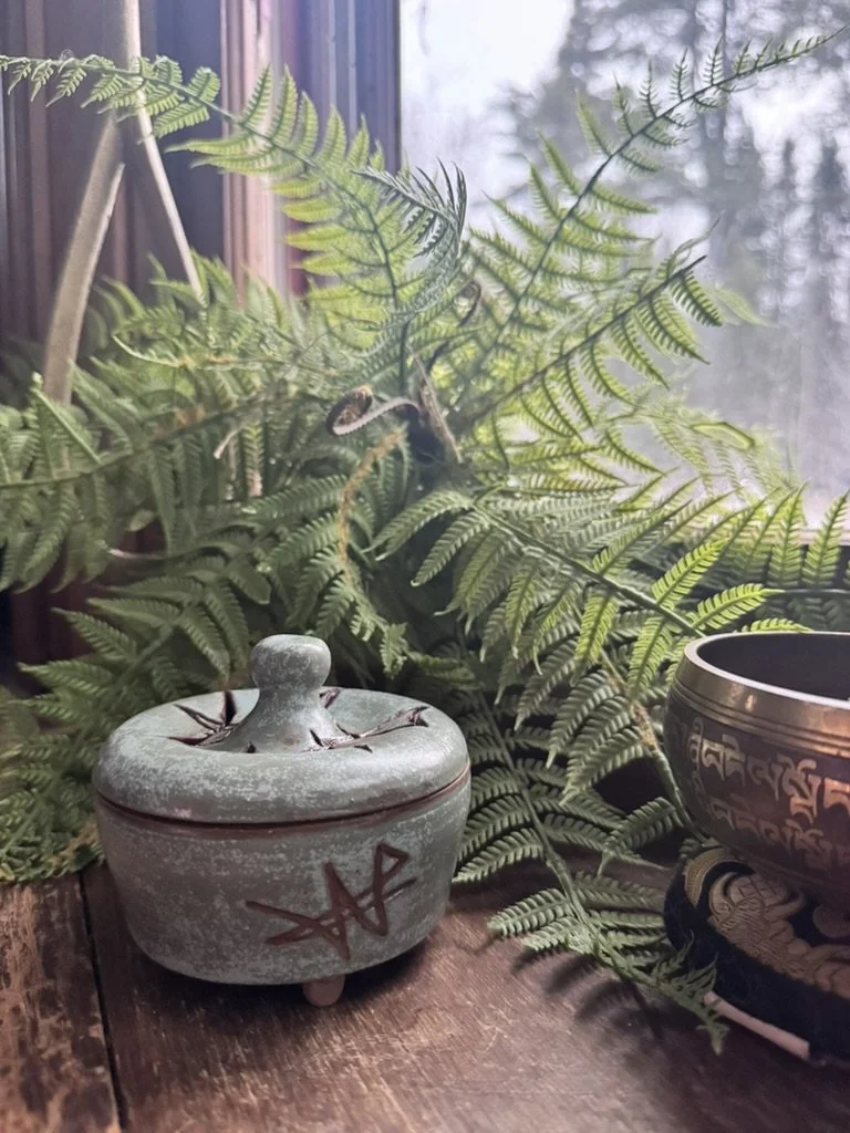 Insence burner with a carved sigil, ferns sitting behind