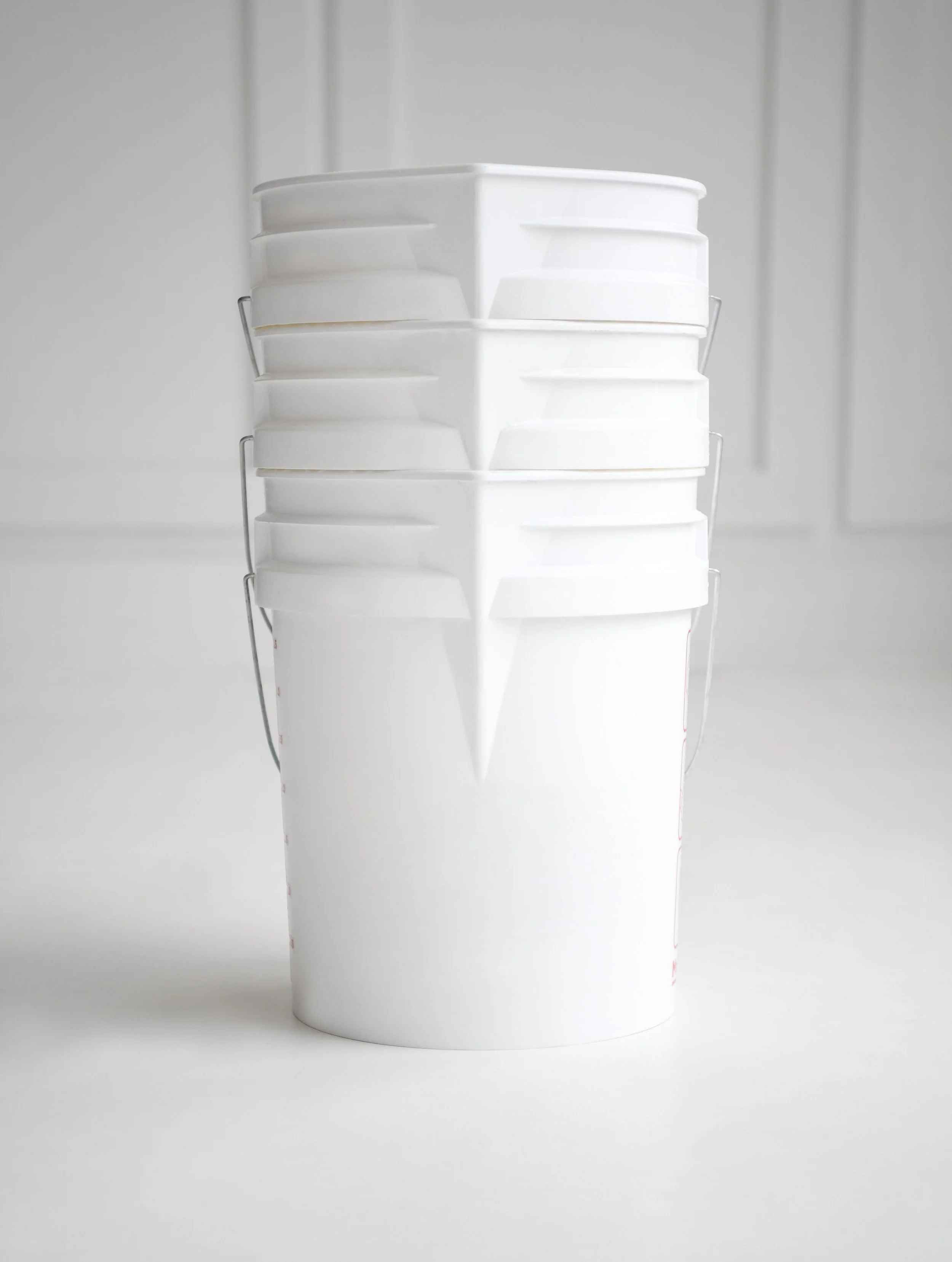 Stacked white buckets with a bird face design printed on one bucket, set against a white background.