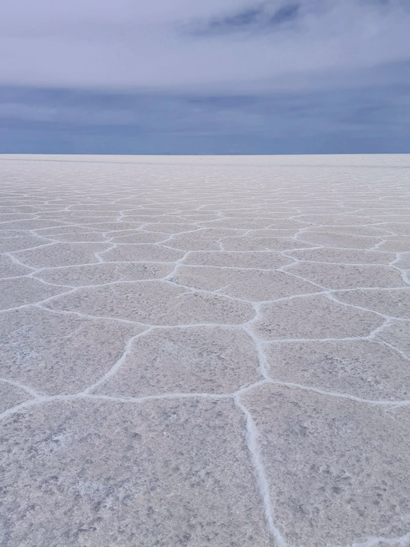 Endless salt polygons stretch toward a pale horizon, where sky and earth blur into quiet infinity. Uyuni feels like standing inside a thought: vast, hushed, reflective, and timeless, a place that erases edges and invites wonder without noise or hurry