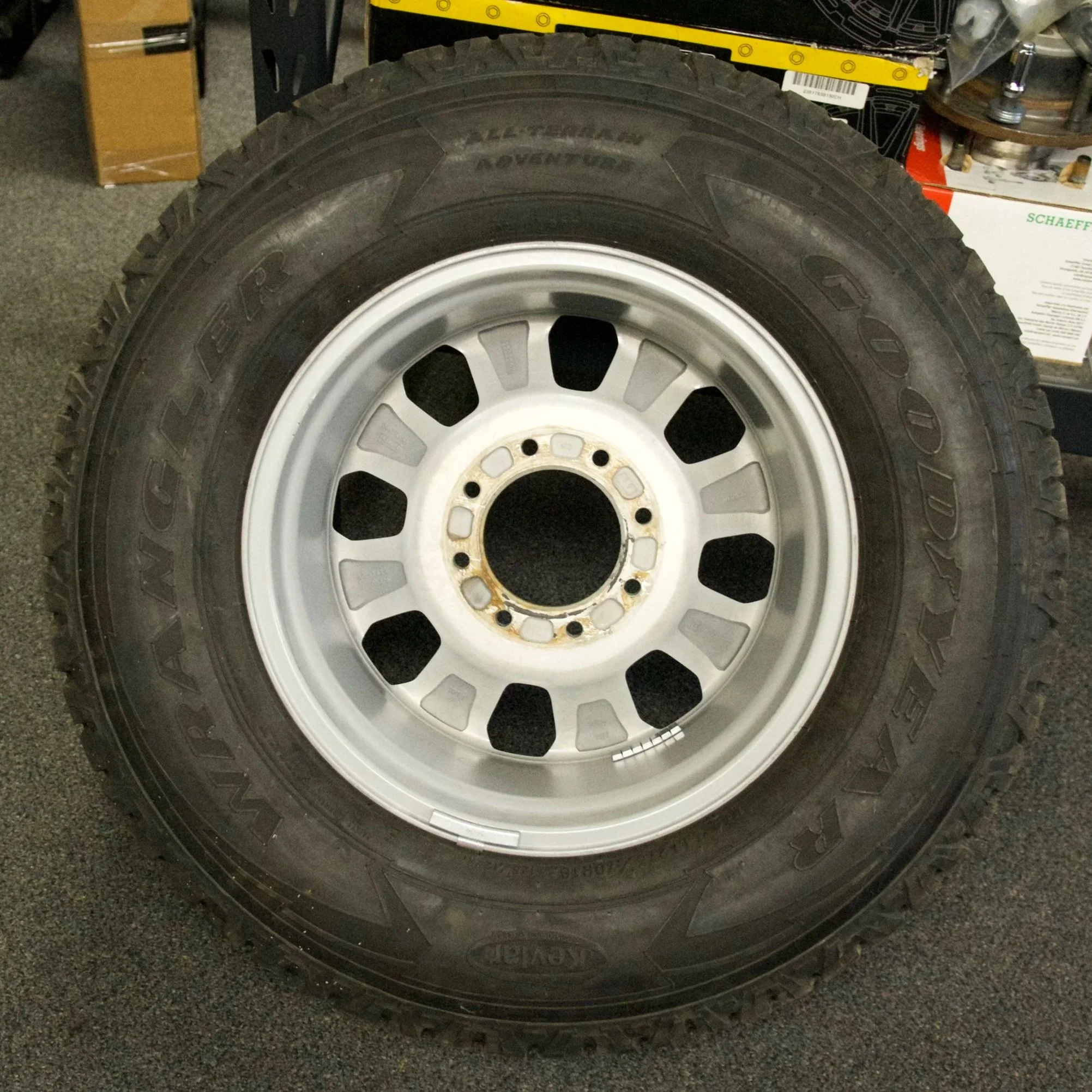 Brand new Goodyear Wrangler All-Terrain Adventure tire mounted on silver multi-spoke alloy rim, ready for 4x4 trucks or classic Bronco builds.