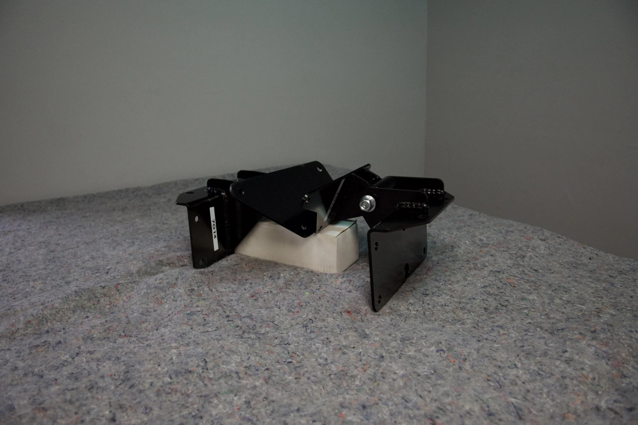 Close-up of Gen2 Ford Bronco/F150 7.3L Godzilla engine mount kit installed, showing frame and engine side mounts for coil spring suspension.