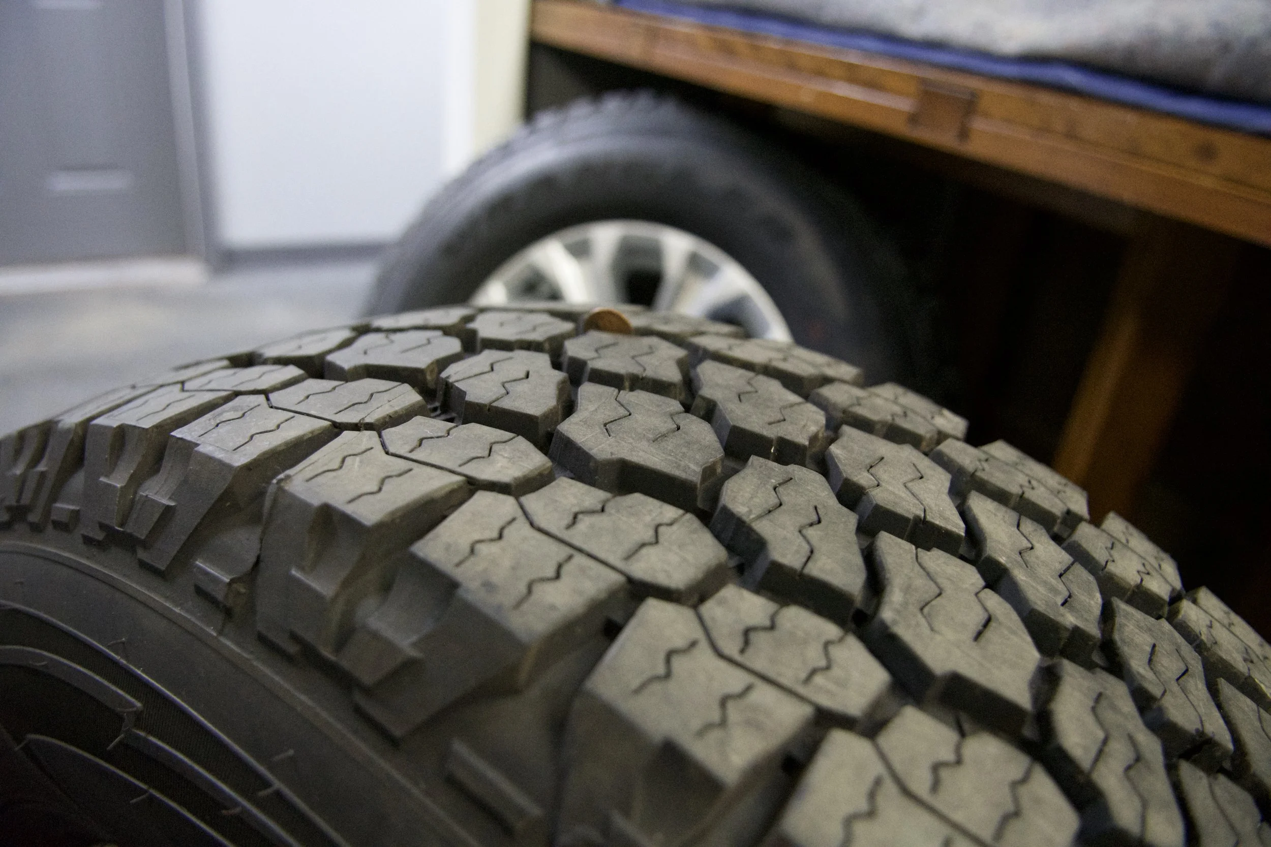 Brand new Goodyear Wrangler All-Terrain Adventure tire mounted on silver multi-spoke alloy rim, ready for 4x4 trucks or classic Bronco builds.
