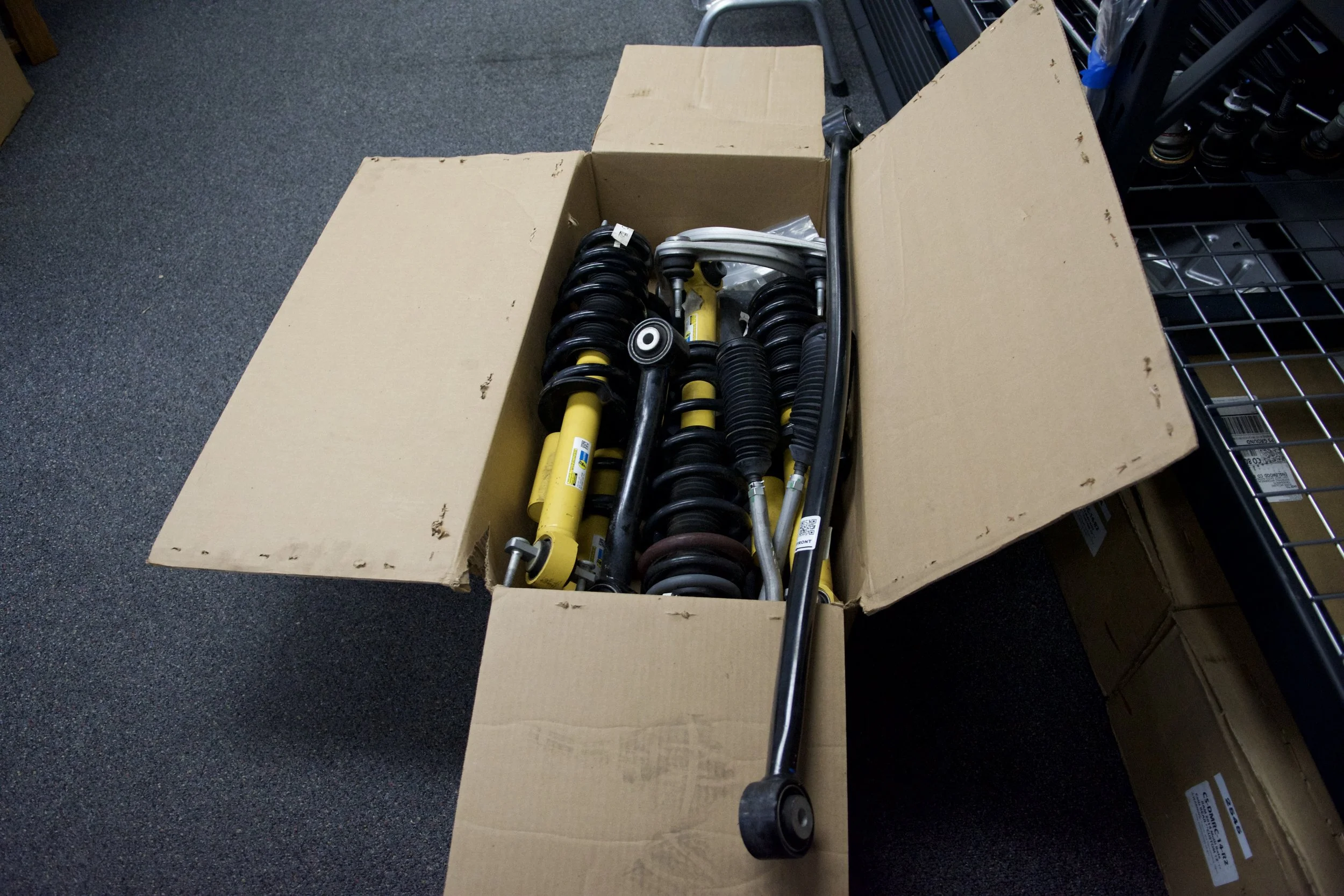 Full OEM Bronco Badlands Suspension Kit laid out on shop floor, labeled with inventory #6001