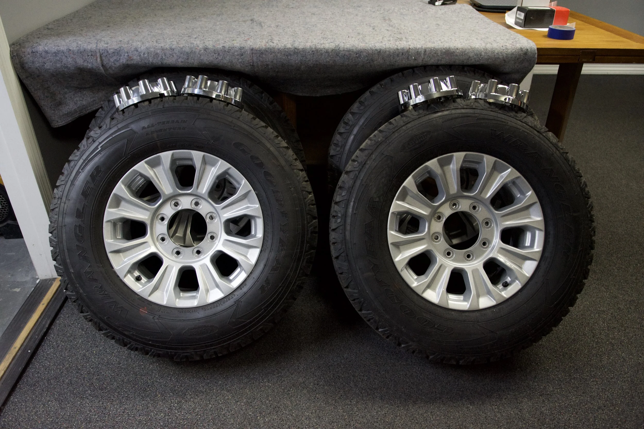 Brand new Goodyear Wrangler All-Terrain Adventure tire mounted on silver multi-spoke alloy rim, ready for 4x4 trucks or classic Bronco builds.