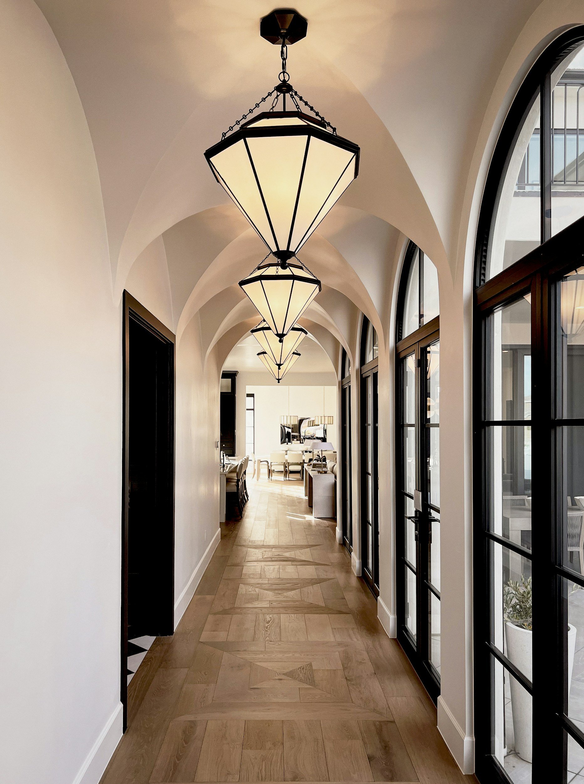 alt="Bright modern pendant lights and recessed ceiling lights in renovated living space"