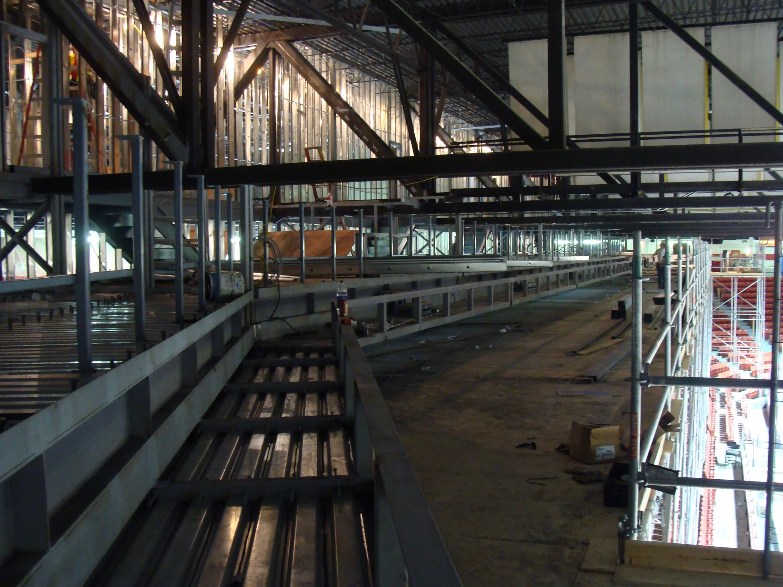 Construction site with scaffolding, metal beams, and unfinished building structure.