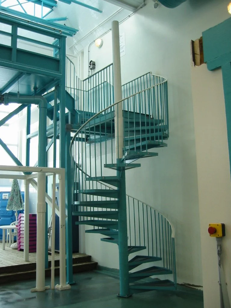 Blue metal spiral staircase inside a building.
