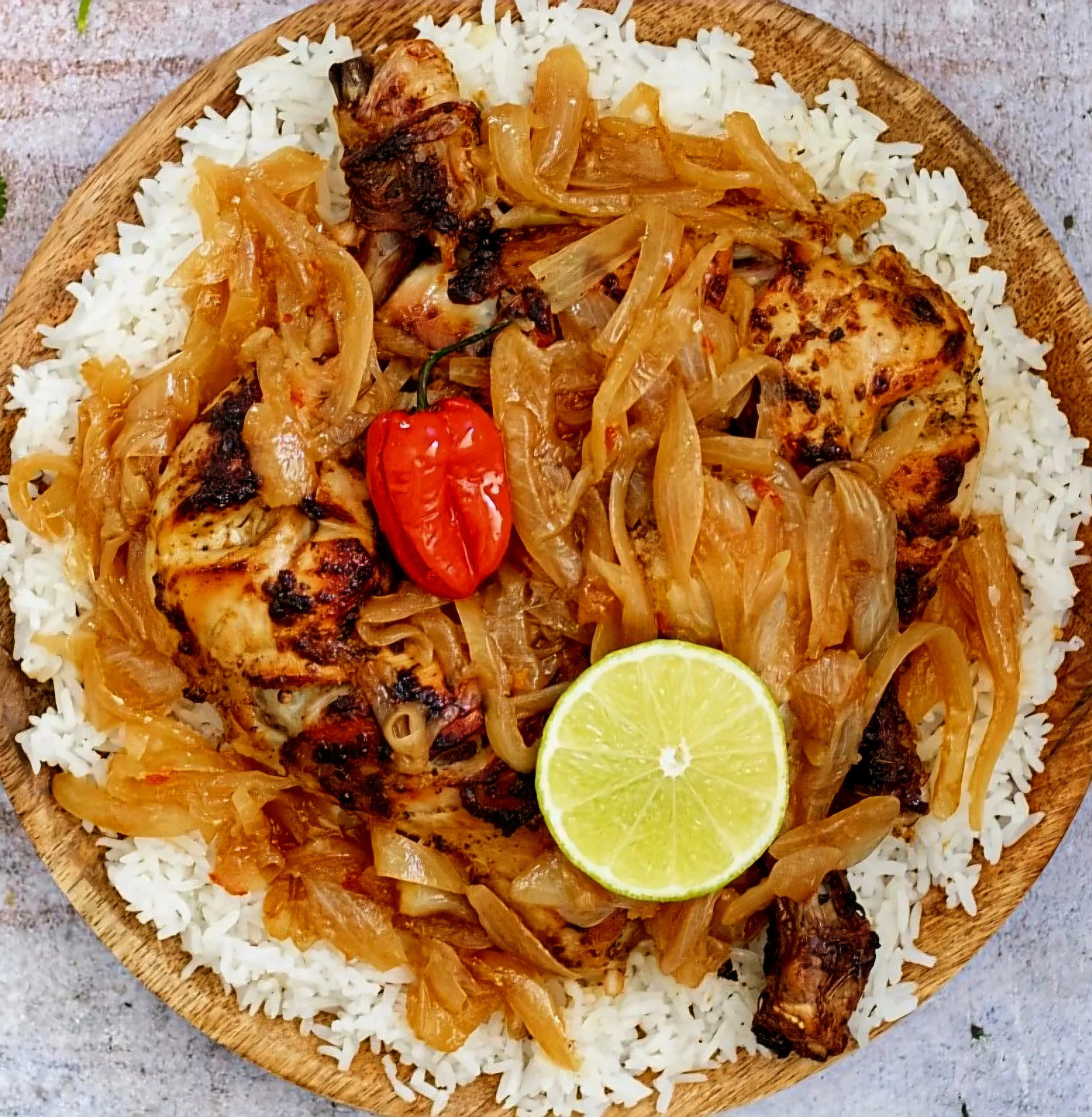 Yassa, een traditioneel Senegalees gerecht met kip, gekaramelliseerde ui, rijst en limoen.