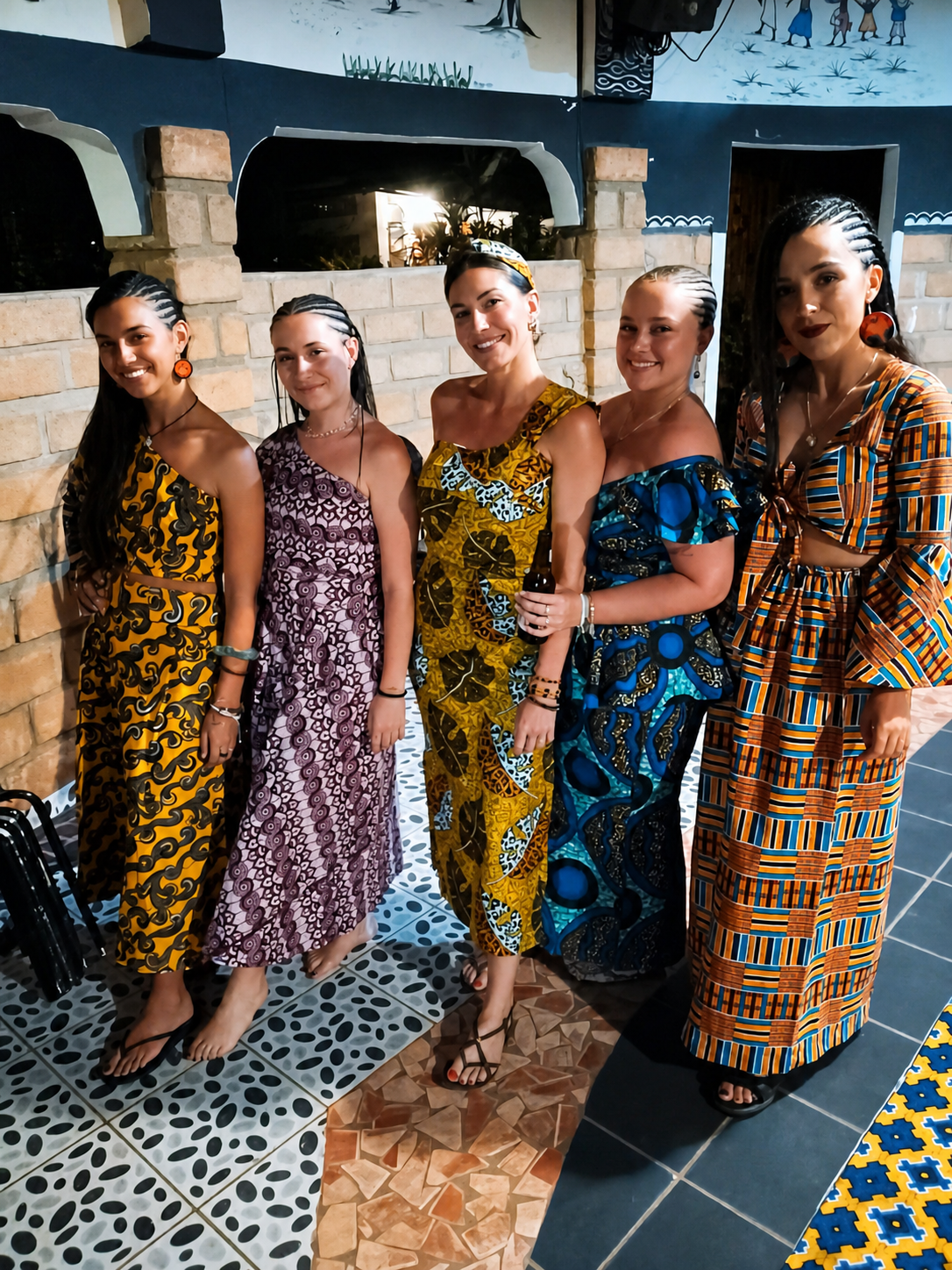 Five women wearing colourful custom-made African clothing in Senegal.