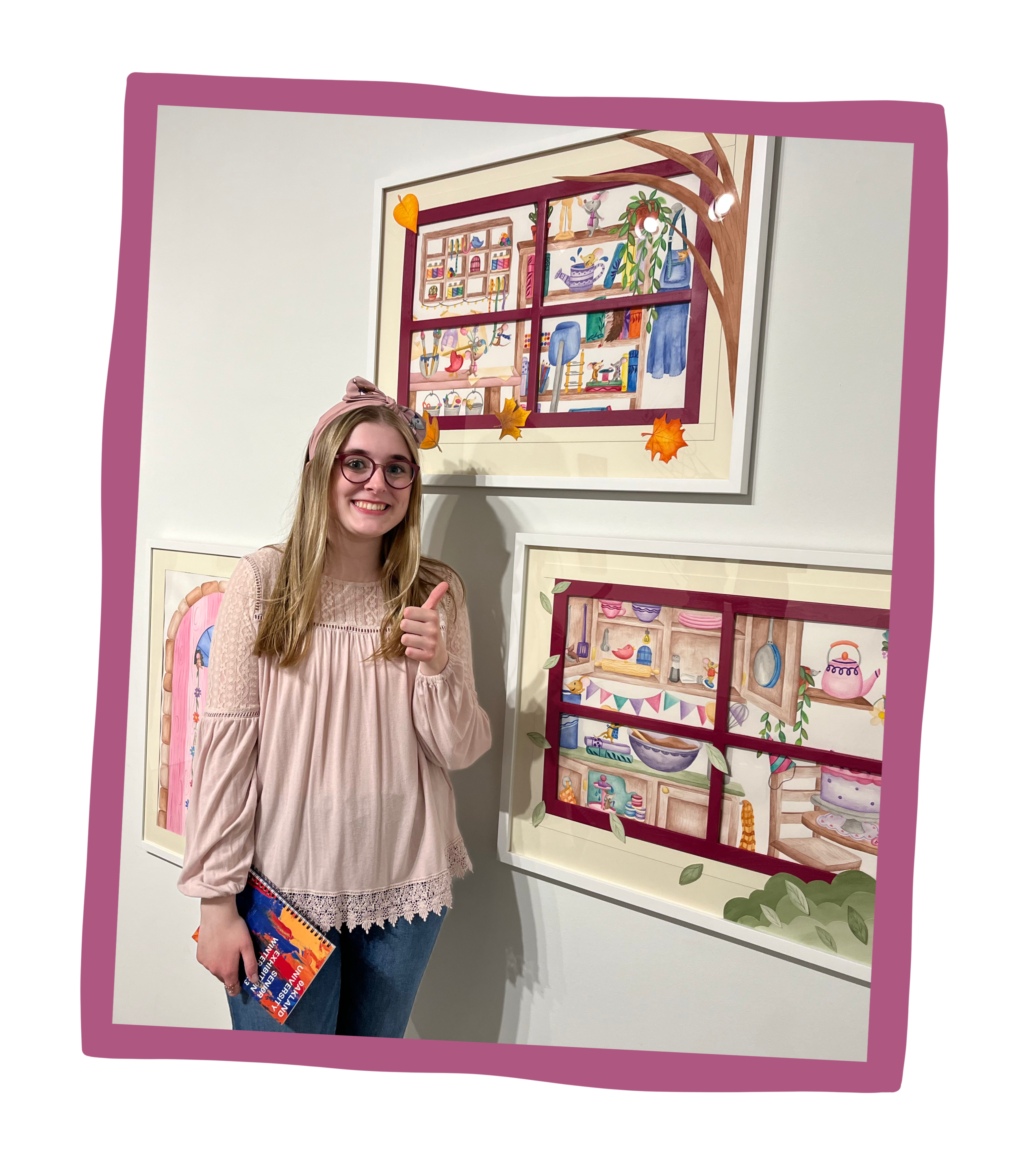 A girl with long, blonde hair and a light pink blouse stands smiling in front of three paintings with her thumbs up.