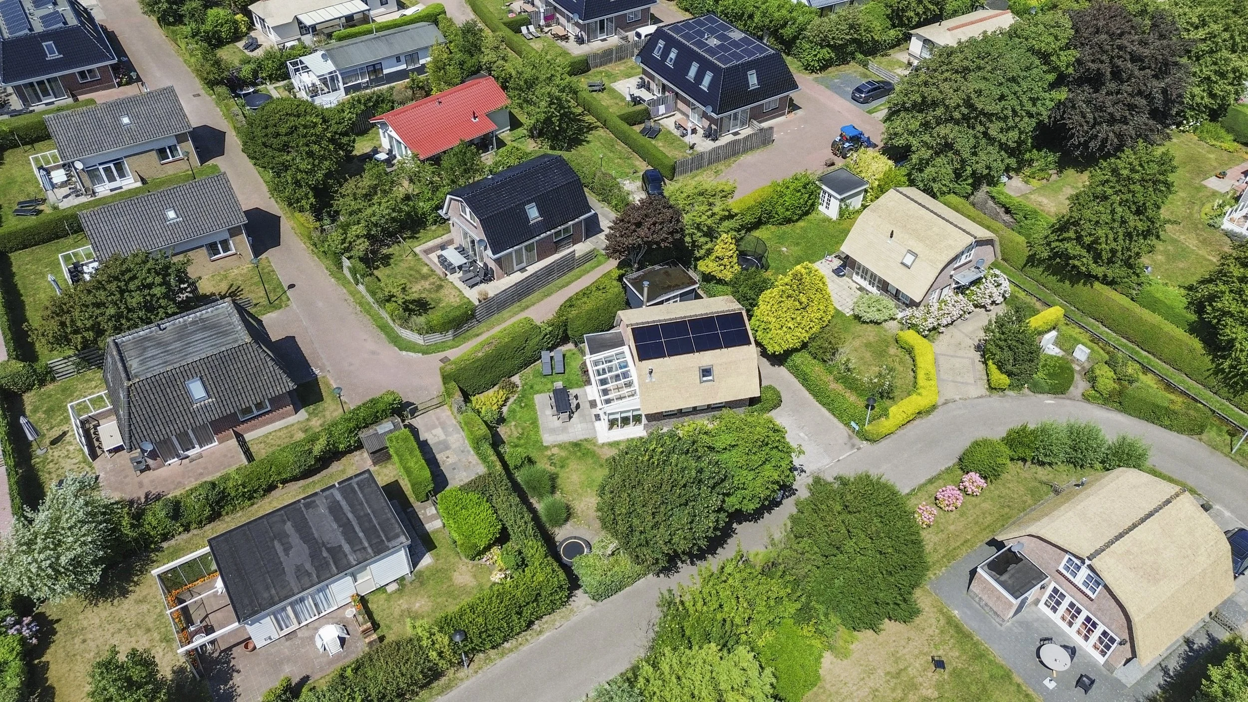 Luchtfoto van een woonwijk met verschillende huizen en groene tuinen