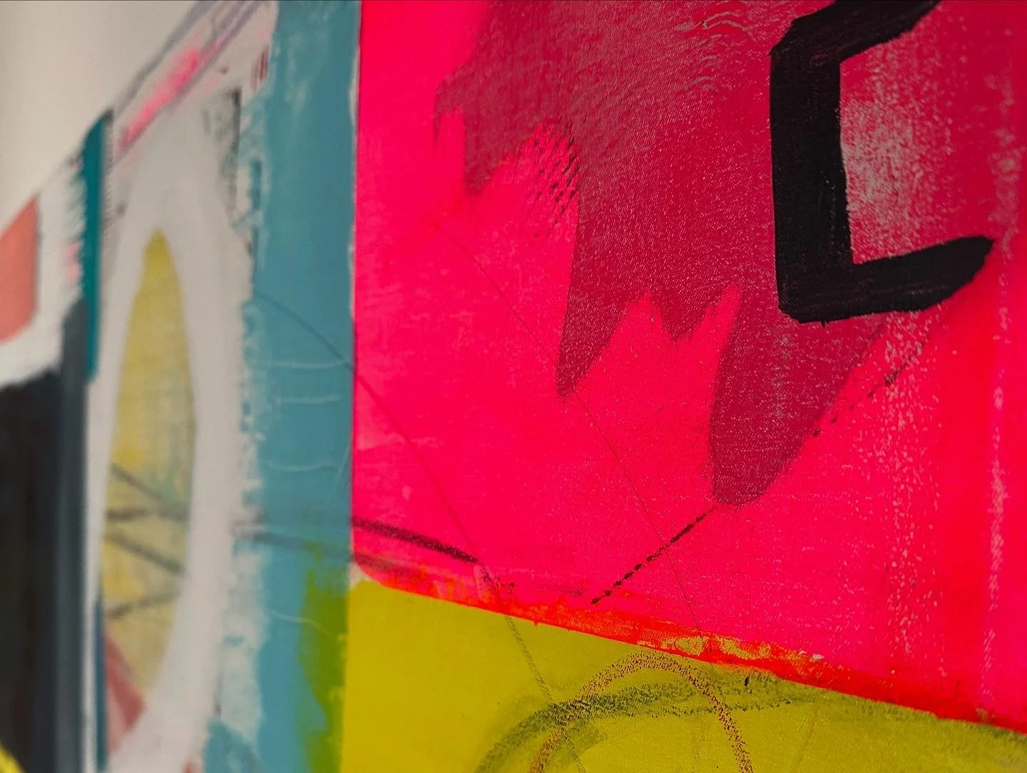 Ein farbenfrohes Kunstwerk mit leuchtend pinken, blauen, gelben und schwarzen Akzenten, auf einer Wand gemalt.