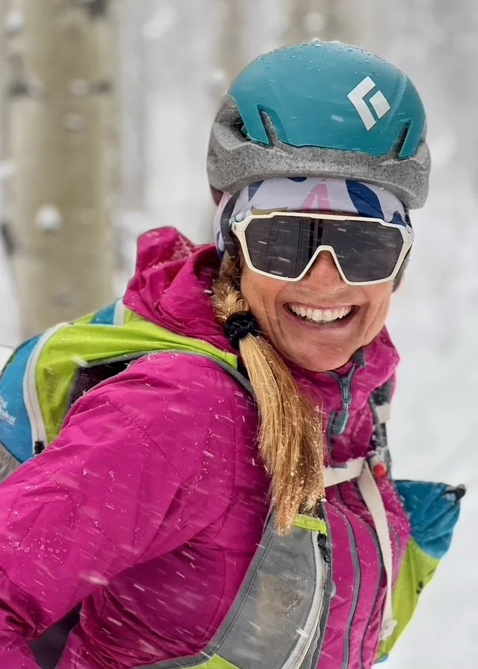 NEVE coach Carolyn Williams smiles as she skis in a snowstorm.