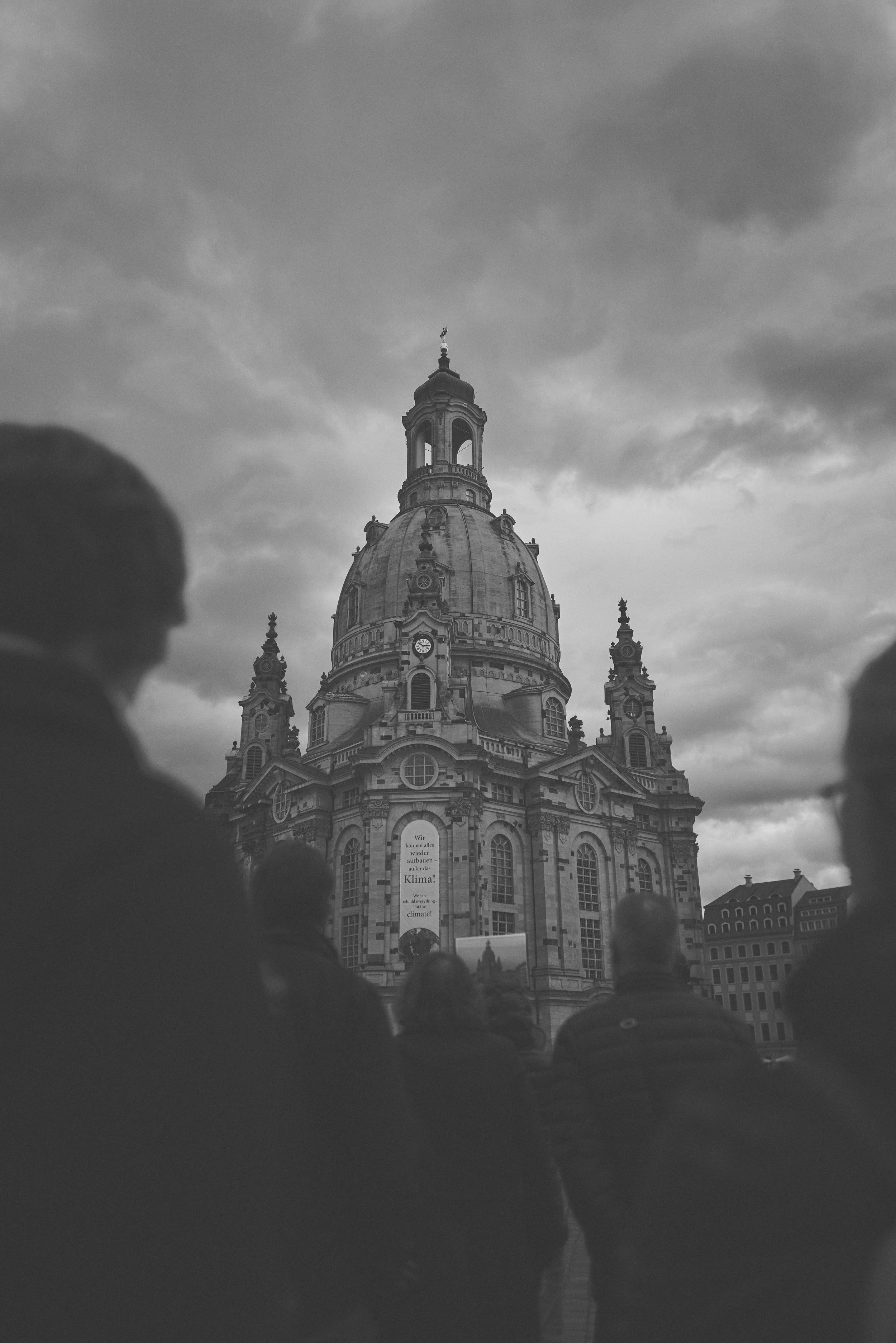 Schwarz-Weiß-Foto vom Frauenkirche in Dresden, gesehen von unten mit mehreren Menschen im Vordergrund.