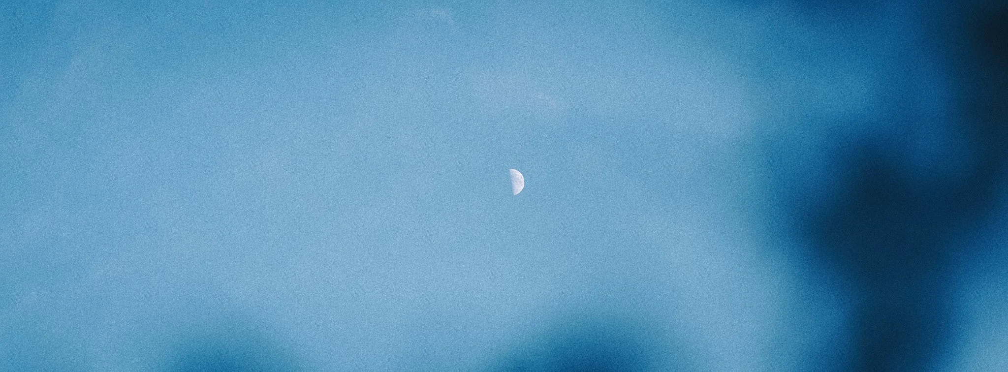 Der Himmel mit einer sichtbaren Mondsichel in einiger Entfernung.