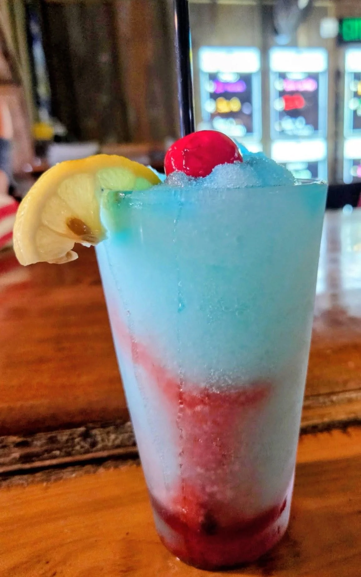Red, white, and blue frozen Raspberry Lemonade cocktail with raspberry vodka, blue curacao, sour mix, and grenadine, served at Milltop Tavern bar in St. Augustine.