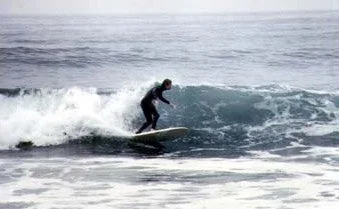 Person surfing on a wave in the ocean.