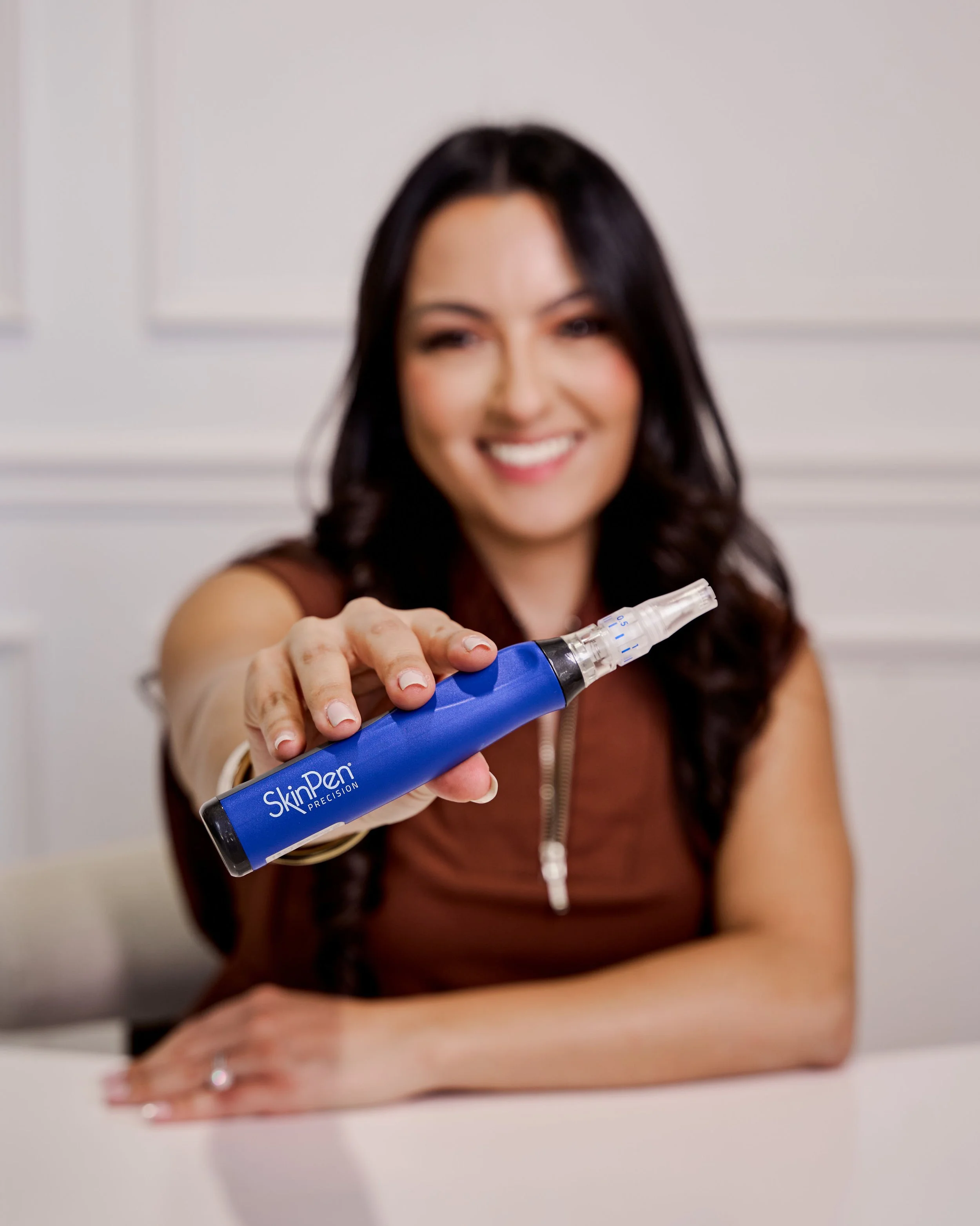 A person with closed eyes getting a facial treatment with a purple device held by a gloved hand.
