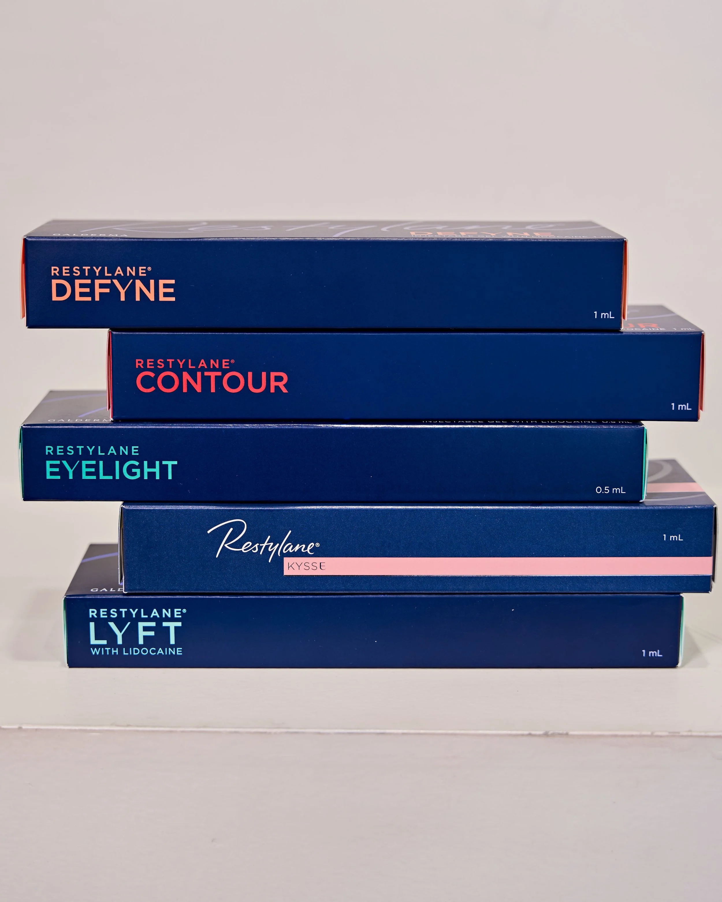 Close-up of a woman receiving a cosmetic injection in her lips, with a healthcare professional holding a syringe and wearing gloves.