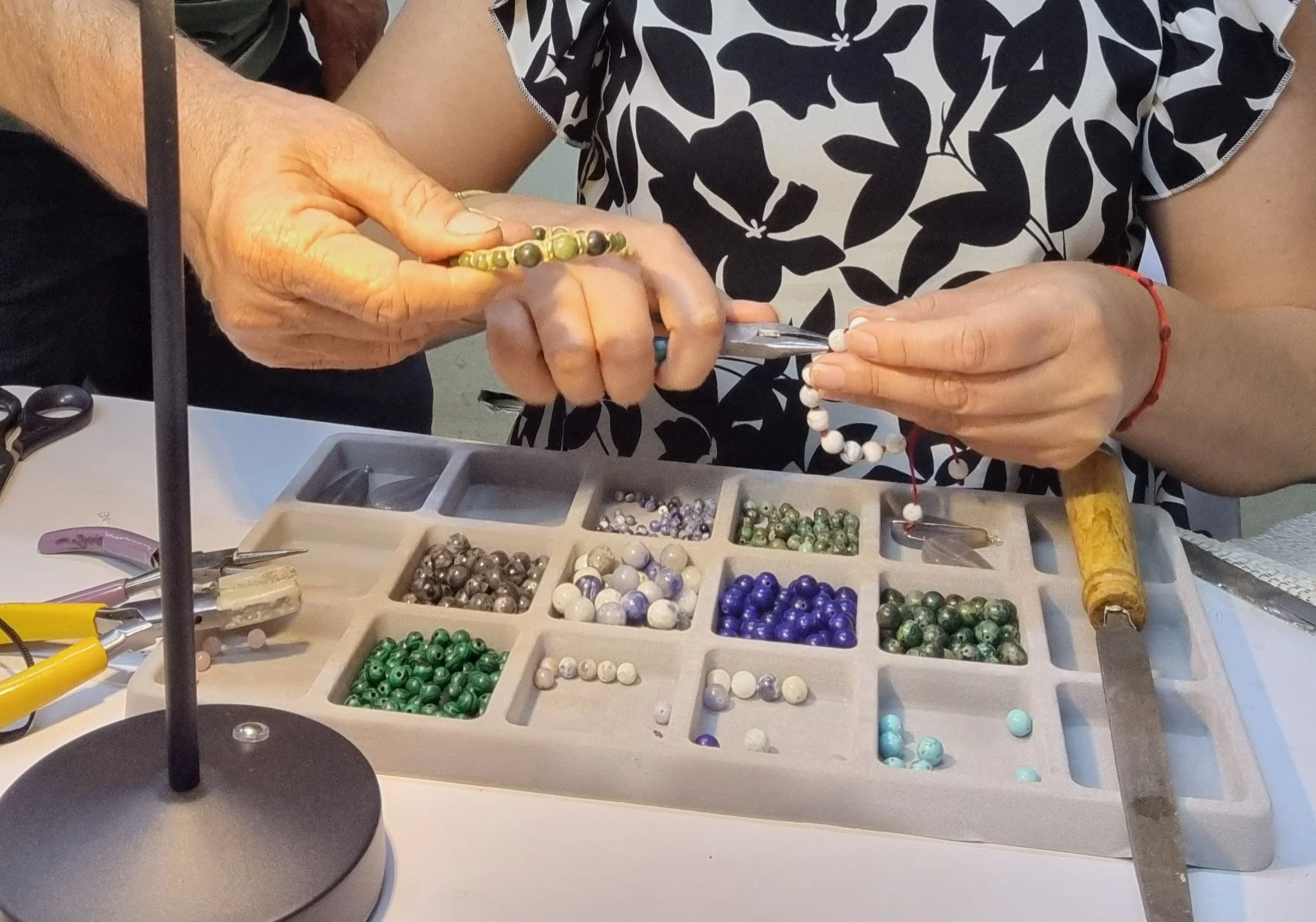 Manos de la familia de NM Joyería armando pulseras con piedras naturales en su taller de Ensenada