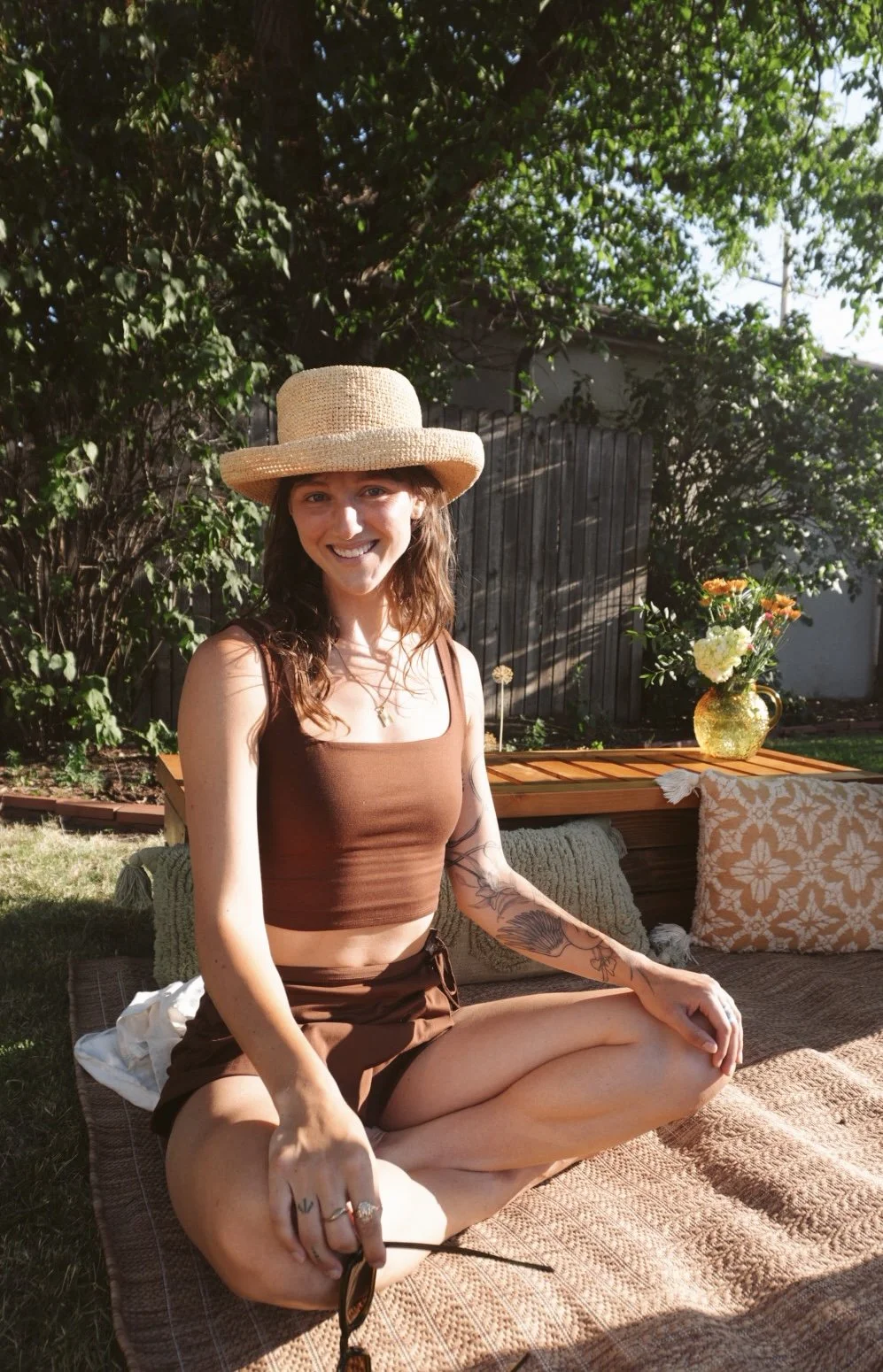 Sam Cuneo, Denver doula, smiling outdoors in a backyard setting