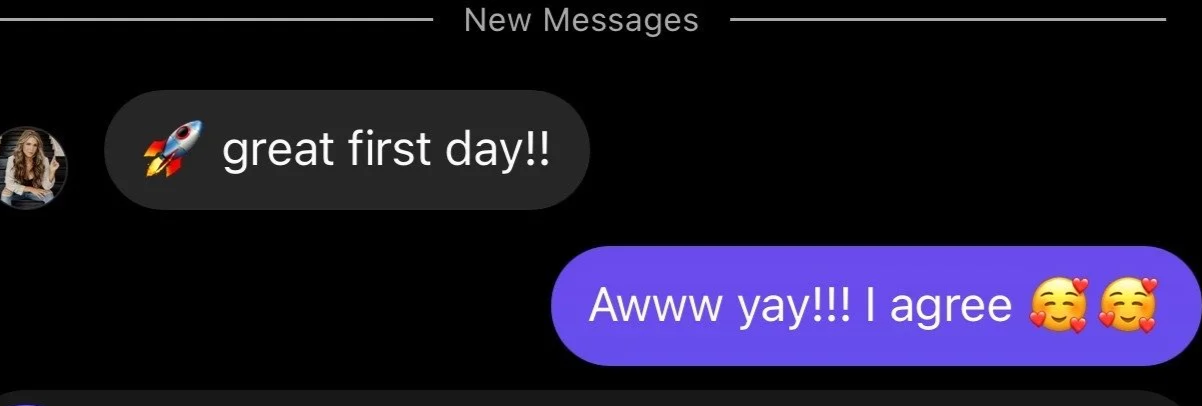 Text message conversation with a black background: person sends a rocket emoji and says 'great first day!!', and the other person responds with 'Awww yay!!! I agree' with smiling face and heart emojis.