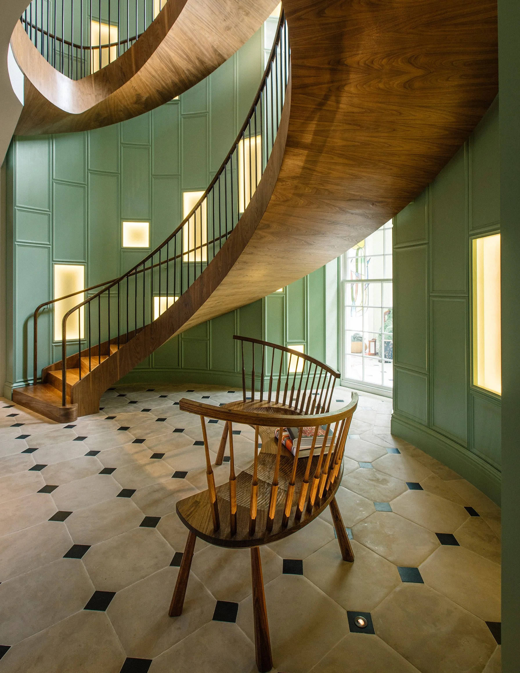 Curved walnut settee with hand-shaped spindles