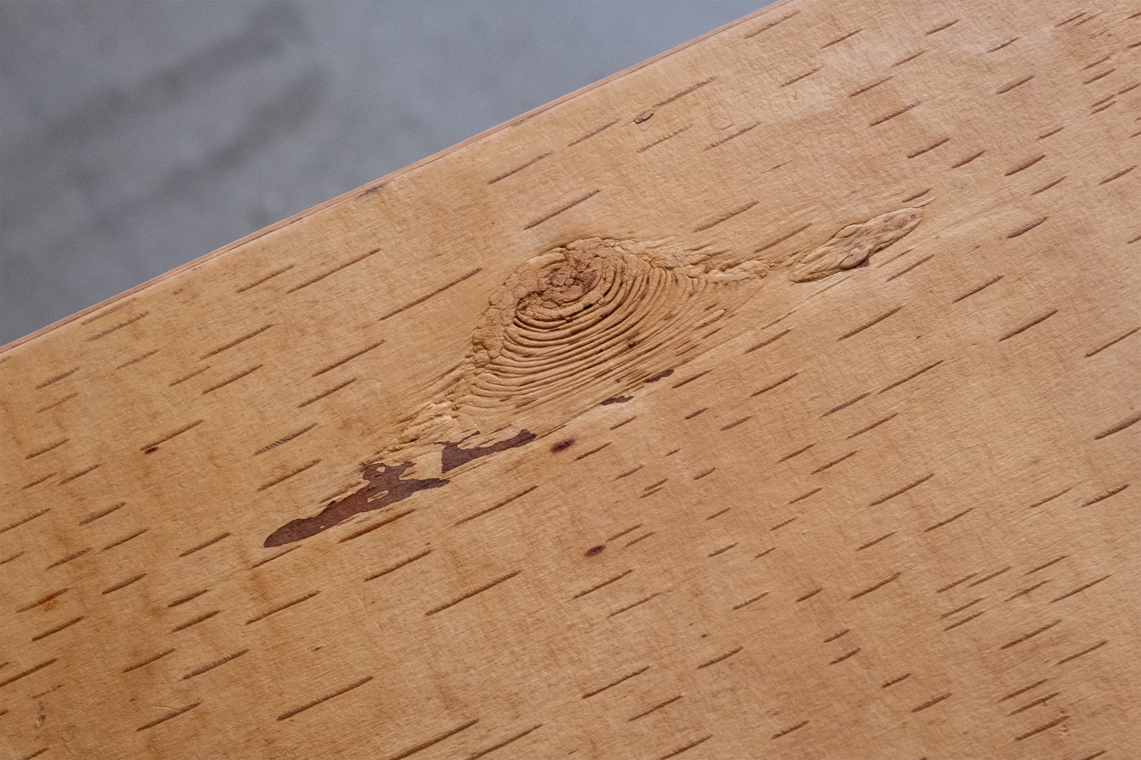 Detail of the side table’s birch bark top, showing its golden colour, fine markings and natural variation.