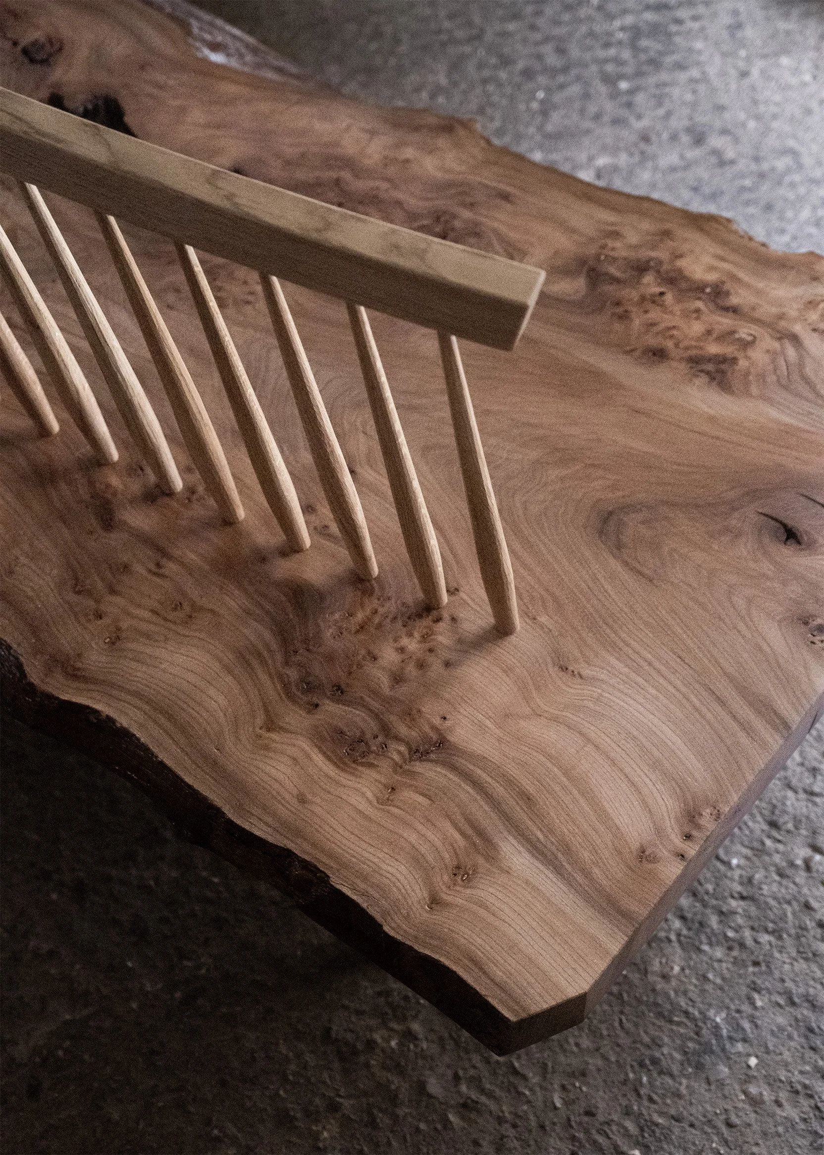 Close-up of a elm bench with a natural edge and featuring a spindle back.