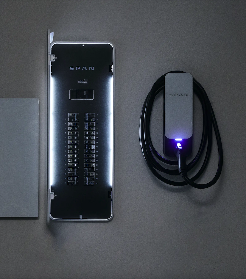 Electric panel with the word "SPAN" and adjacent electric charger with coiled cable on a wall.